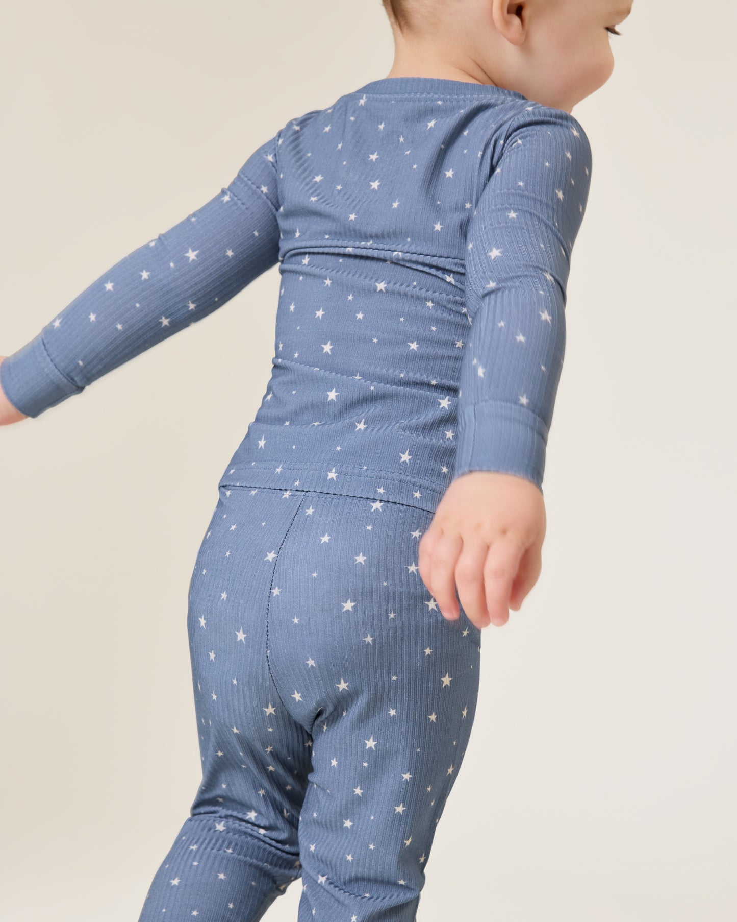 Baby wearing the Ribbed Bamboo Baby Two-Piece Pajama Set in Blue Stars