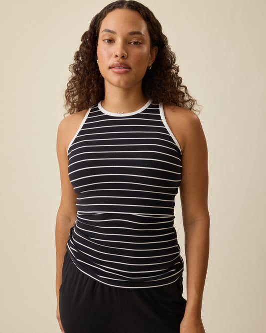Model wearing Ribbed Bamboo Scoop Neck Nursing Tank in Black White Stripe on a beige background @model_info:Mei is wearing a Small.