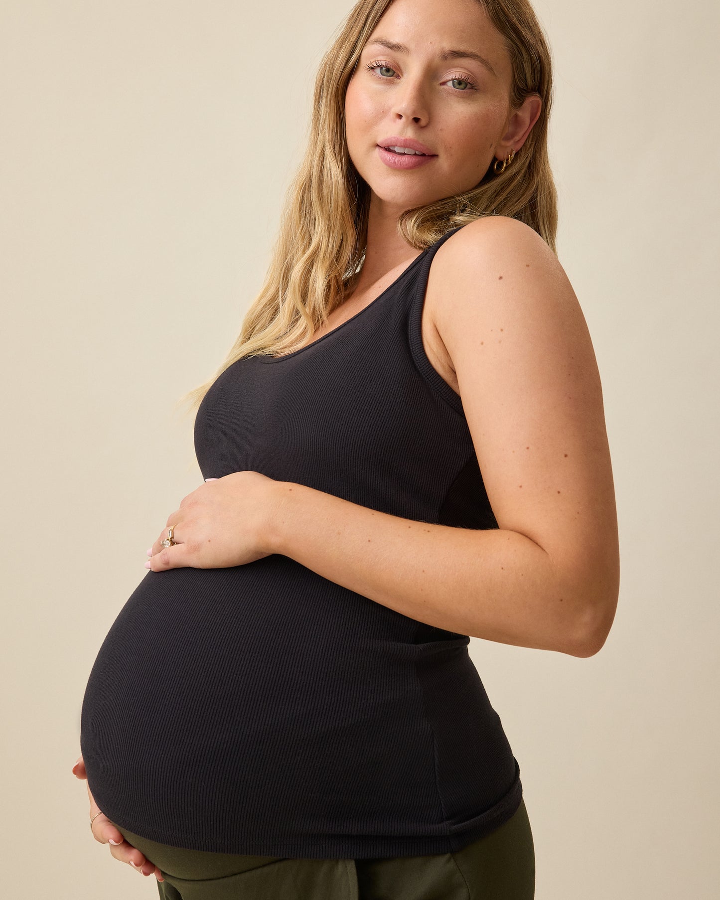 Model wearing Ribbed Bamboo Scoop Neck Nursing Tank in Black on a beige background