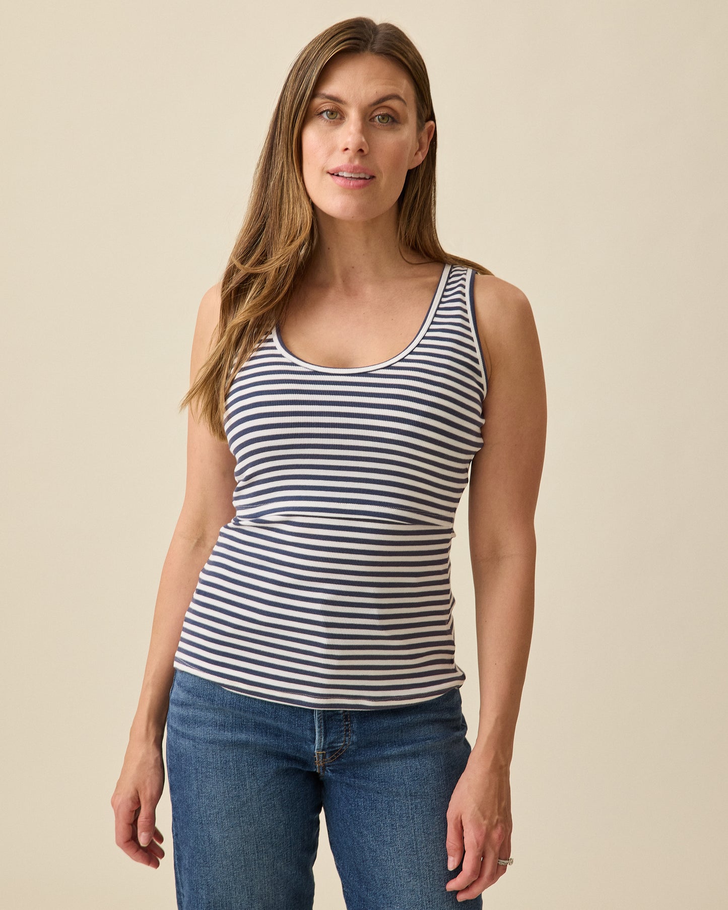Model wearing Ribbed Bamboo Scoop Neck Nursing Tank in Navy White Stripe on a beige background @model_info:Brittany is wearing a Small.