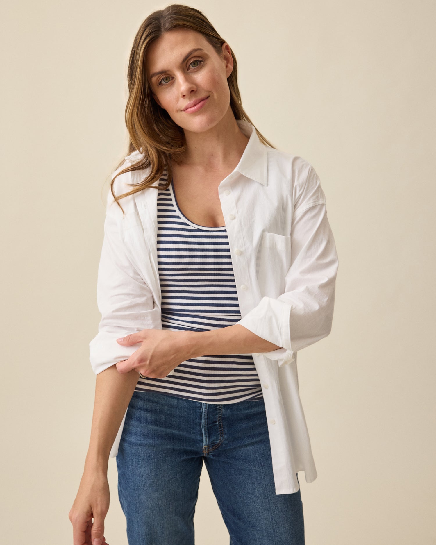 Model wearing Ribbed Bamboo Scoop Neck Nursing Tank in Navy White Stripe on beige background