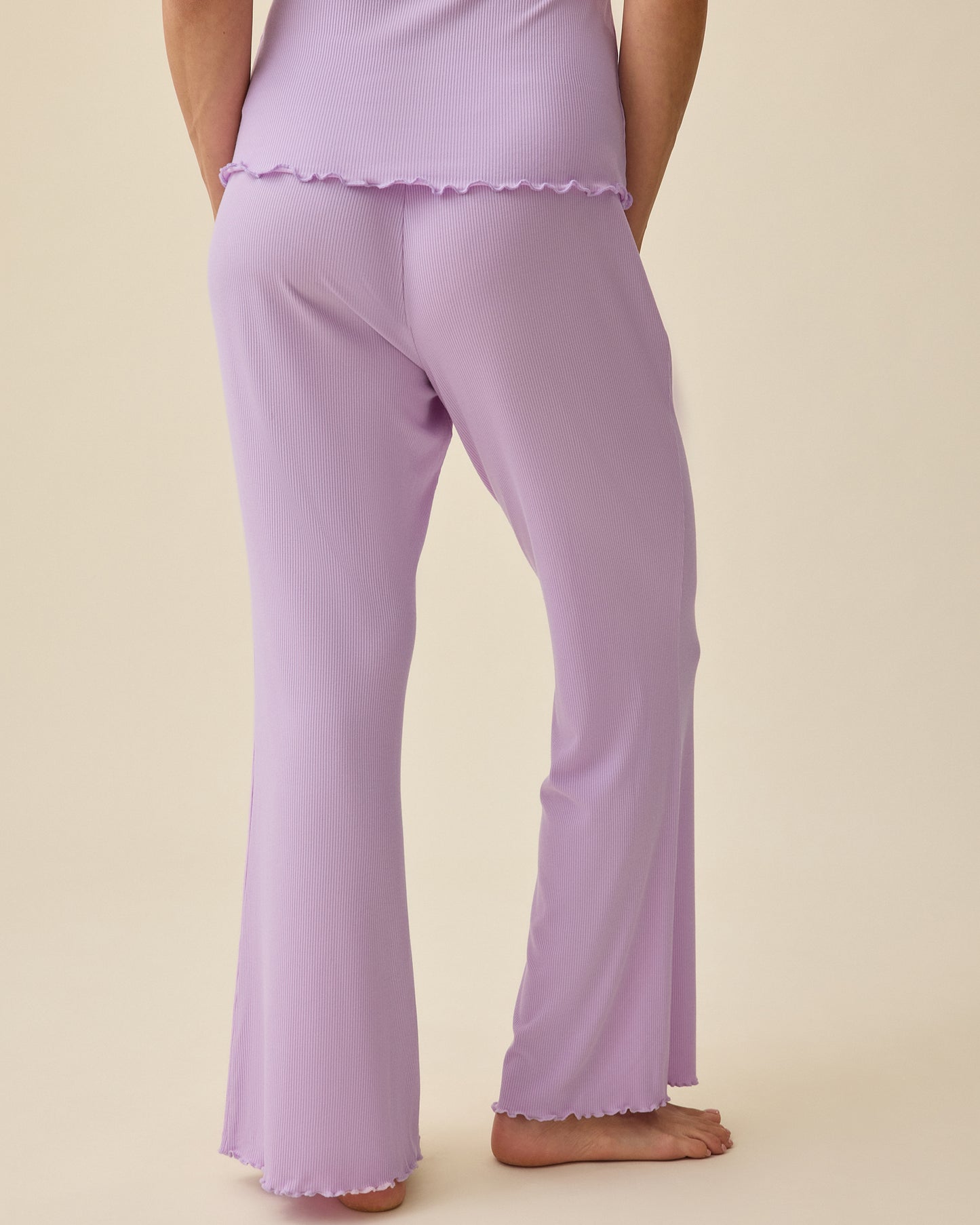 Back view of model wearing Ribbed Modal Nursing Cami and Ribbed Modal Lounge Pant in Lavender on a beige background.