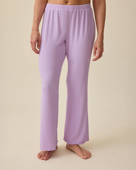 Model wearing Ribbed Modal Lounge Pant in Lavender on a beige background.@model_info:Brittany is 5'7" and wearing a Small.