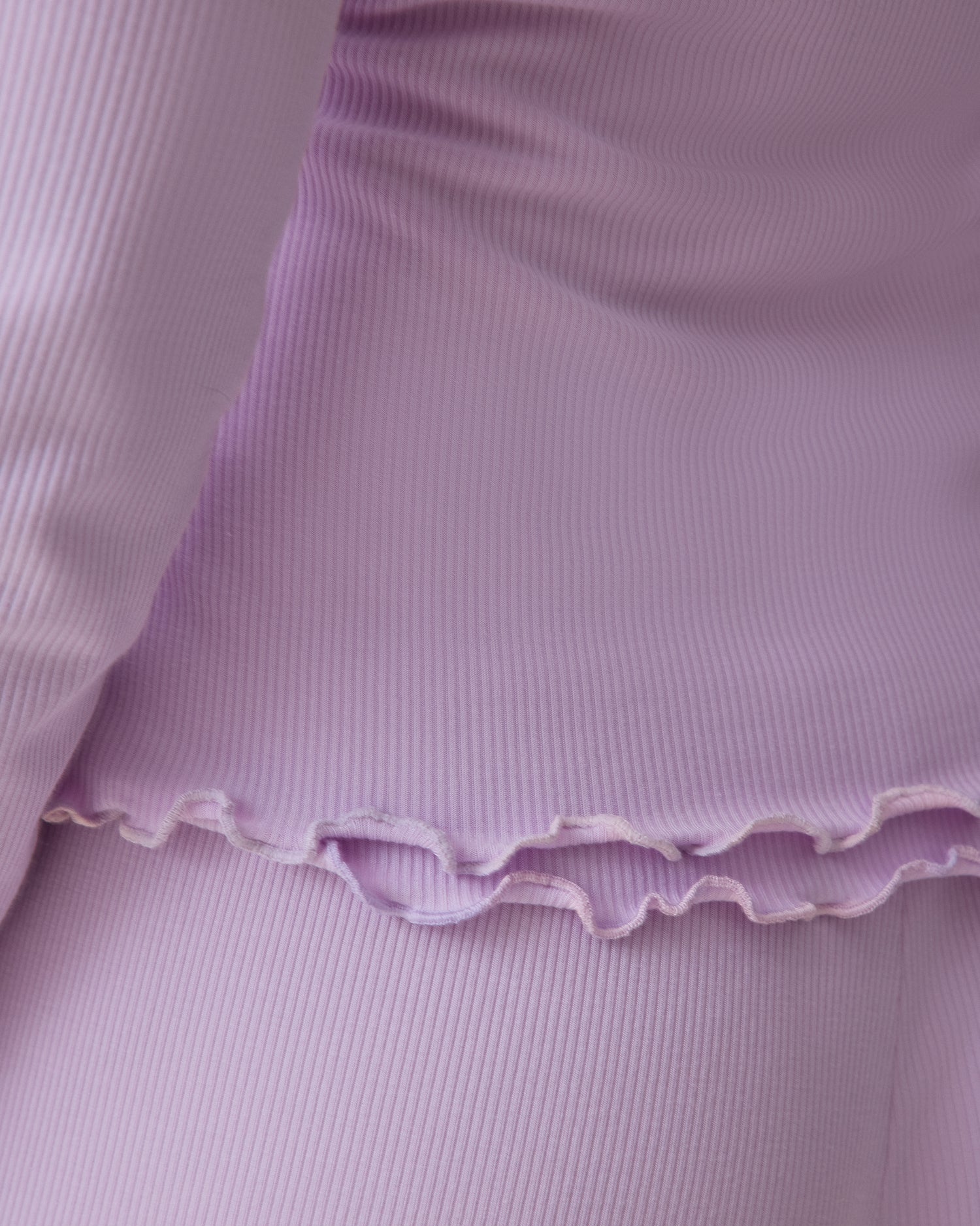 Close-up of ruffled hem detail of Ribbed Modal Nursing Cami in Lavender.