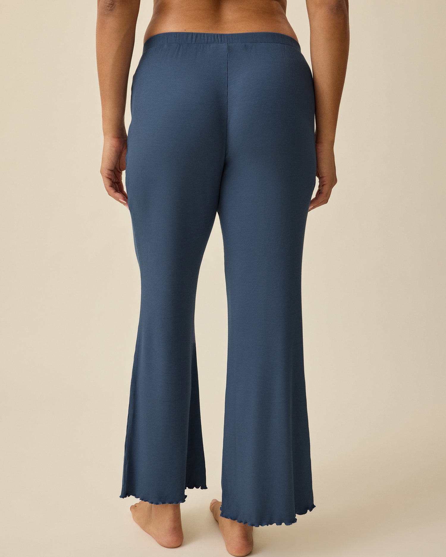 Back view of model wearing Ribbed Modal Lounge Pant in Light Navy on a beige background.