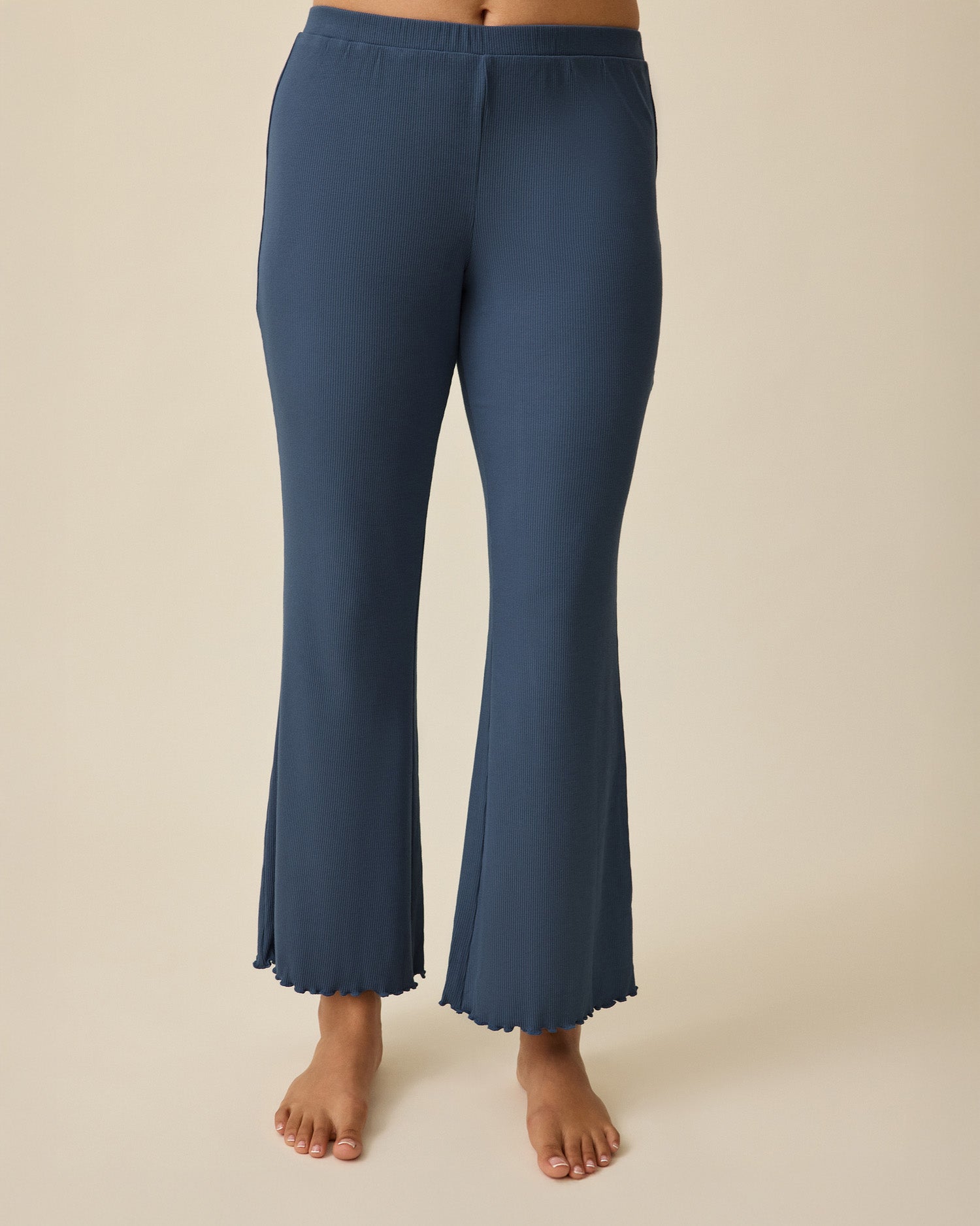 Close-up of model wearing Ribbed Modal Lounge Pant in Light Navy on a beige background.