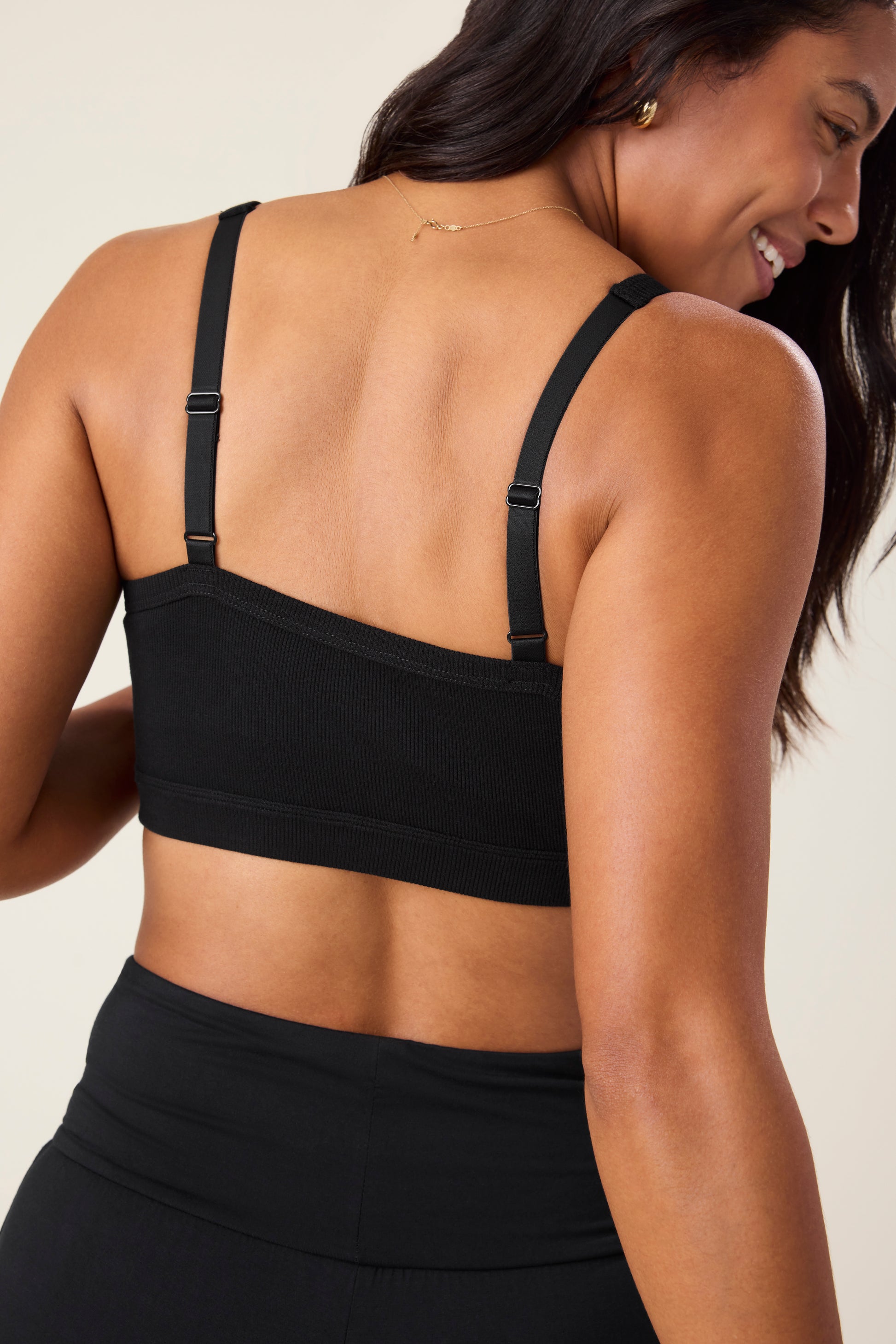 Back of woman wearing the Ribbed Bamboo Pumping Bralette in Black