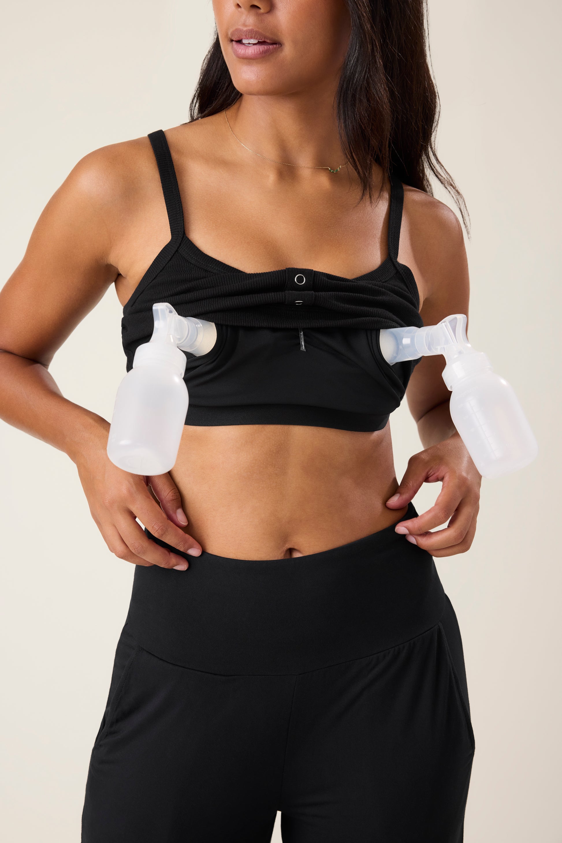 Woman wearing the Ribbed Bamboo Pumping Bralette in Black with two pump flanges in