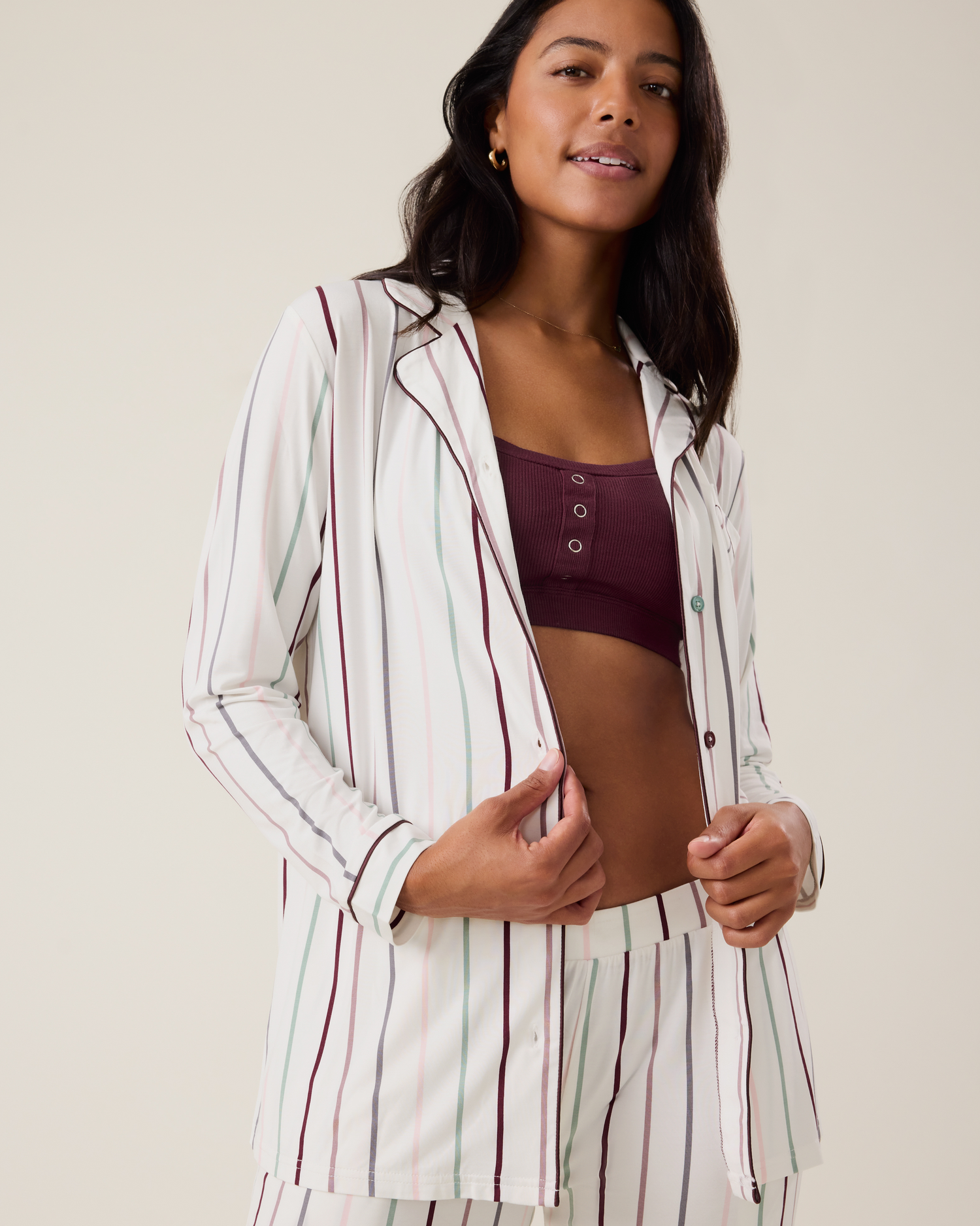 Woman wearing the Clea Bamboo Long Sleeve Pajama Set in Classic Stripe paired with the Ribbed Bamboo Pumping Bralette in Deep Burgundy