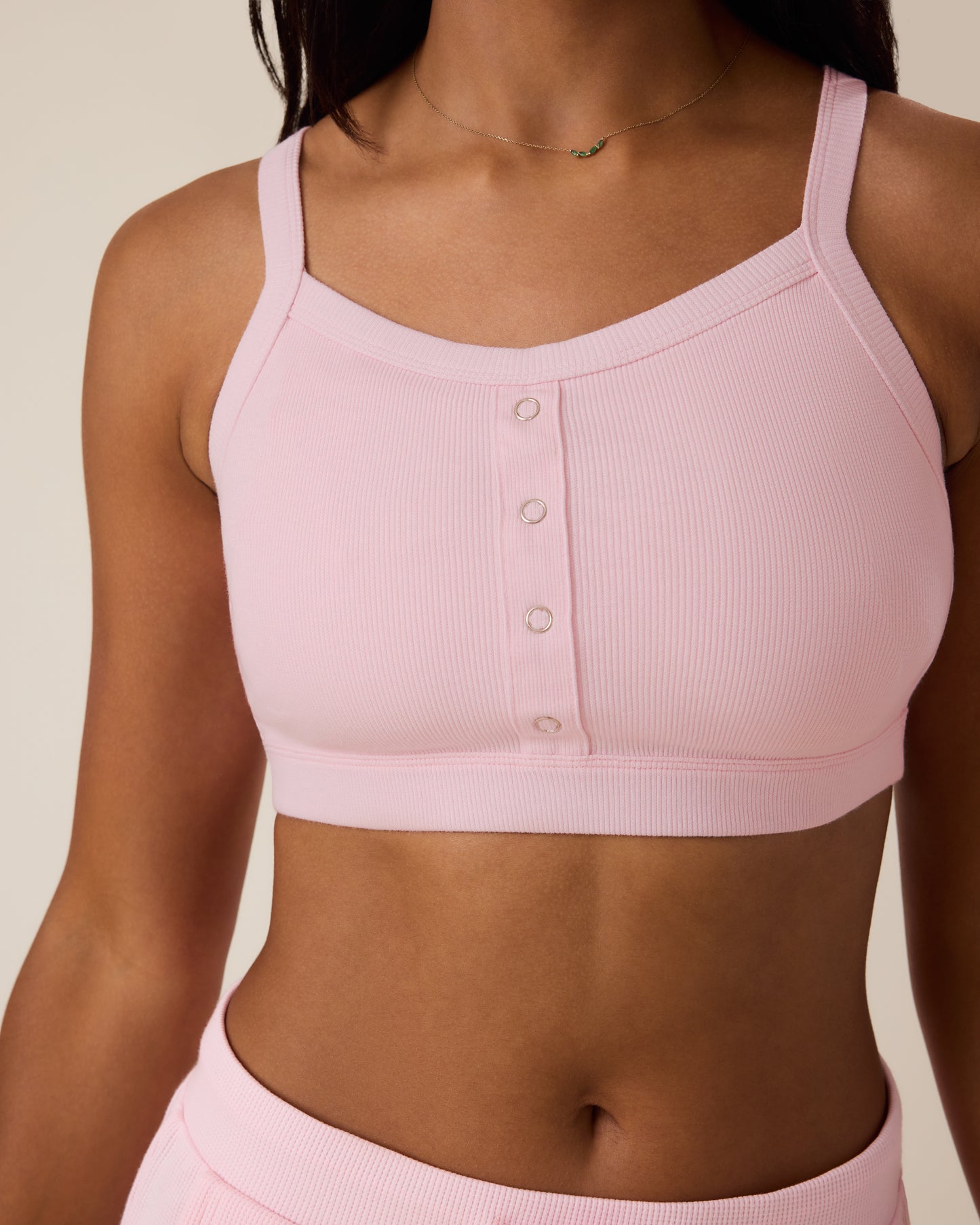 Close up of woman wearing the Ribbed Bamboo Pumping Bralette in Pale Pink showing ribbed fabric and faux snap