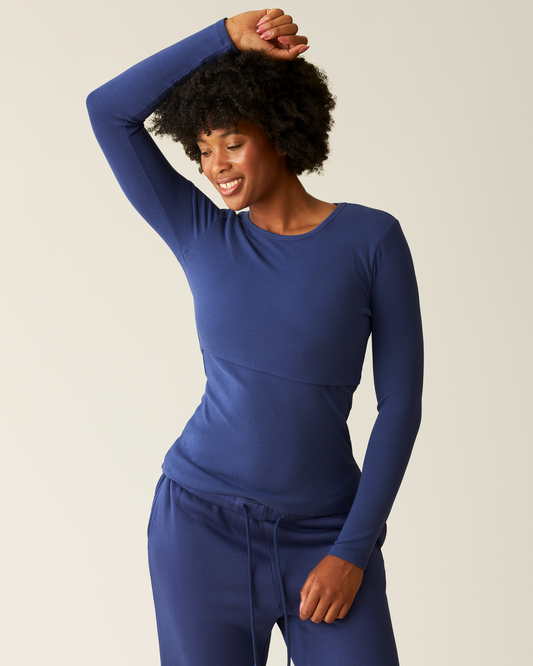 Woman wearing the Ribbed Bamboo Long Sleeve Nursing T-shirt in Deep Blue on beige background @model_info:Kyra is wearing a Small.