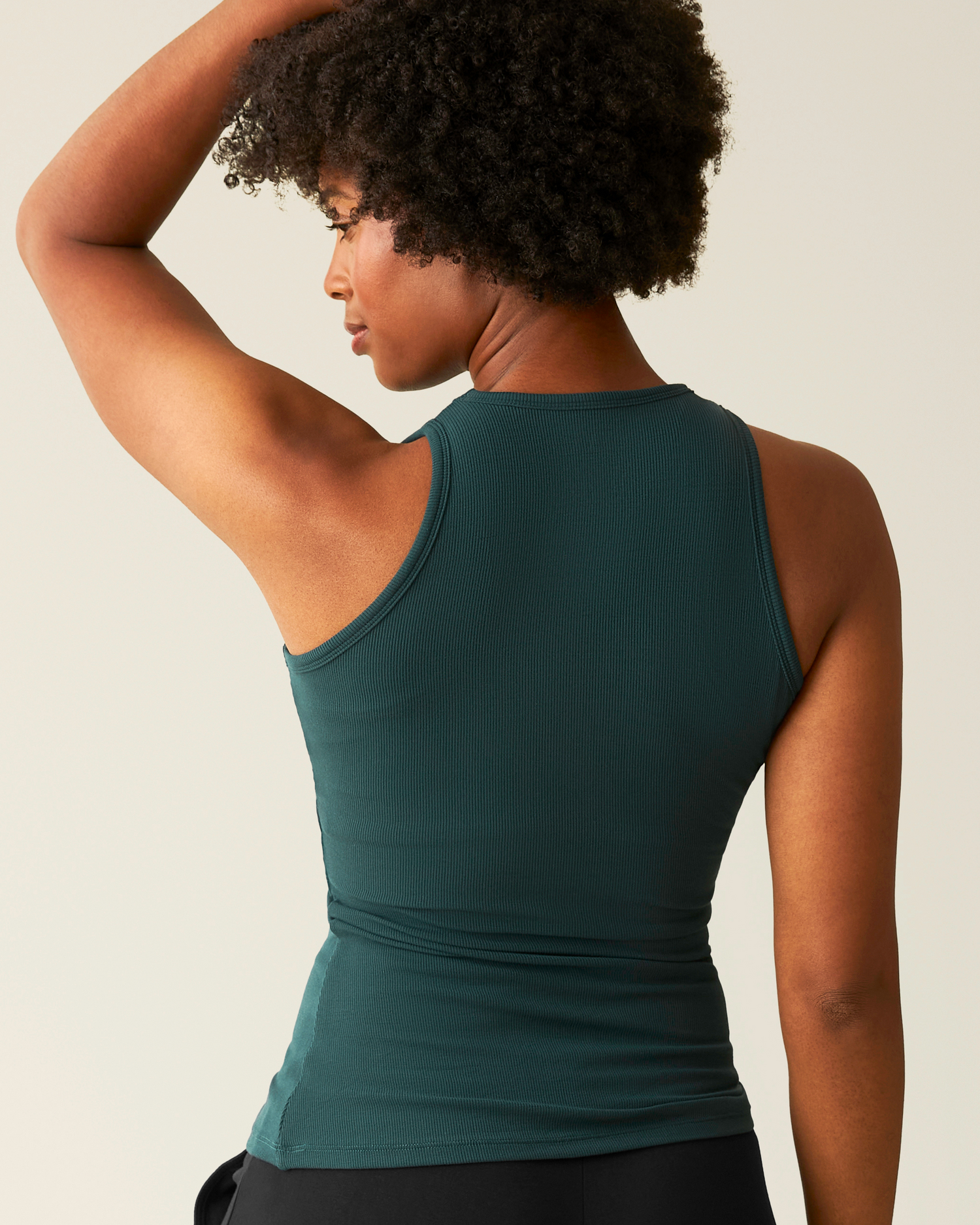 Woman wearing the Ribbed Bamboo Racerback Nursing Tank in Evergreen, showing back of top
