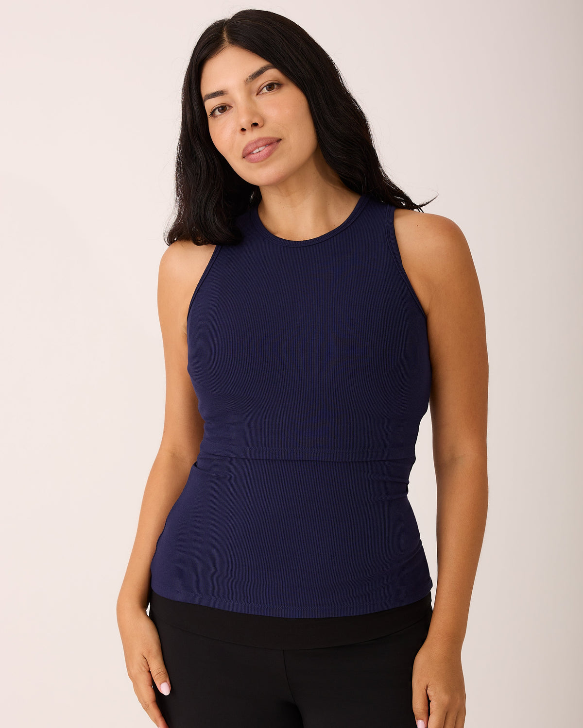 Model is wearing Ribbed Bamboo Racerback Nursing Tank in Navy on a beige background.