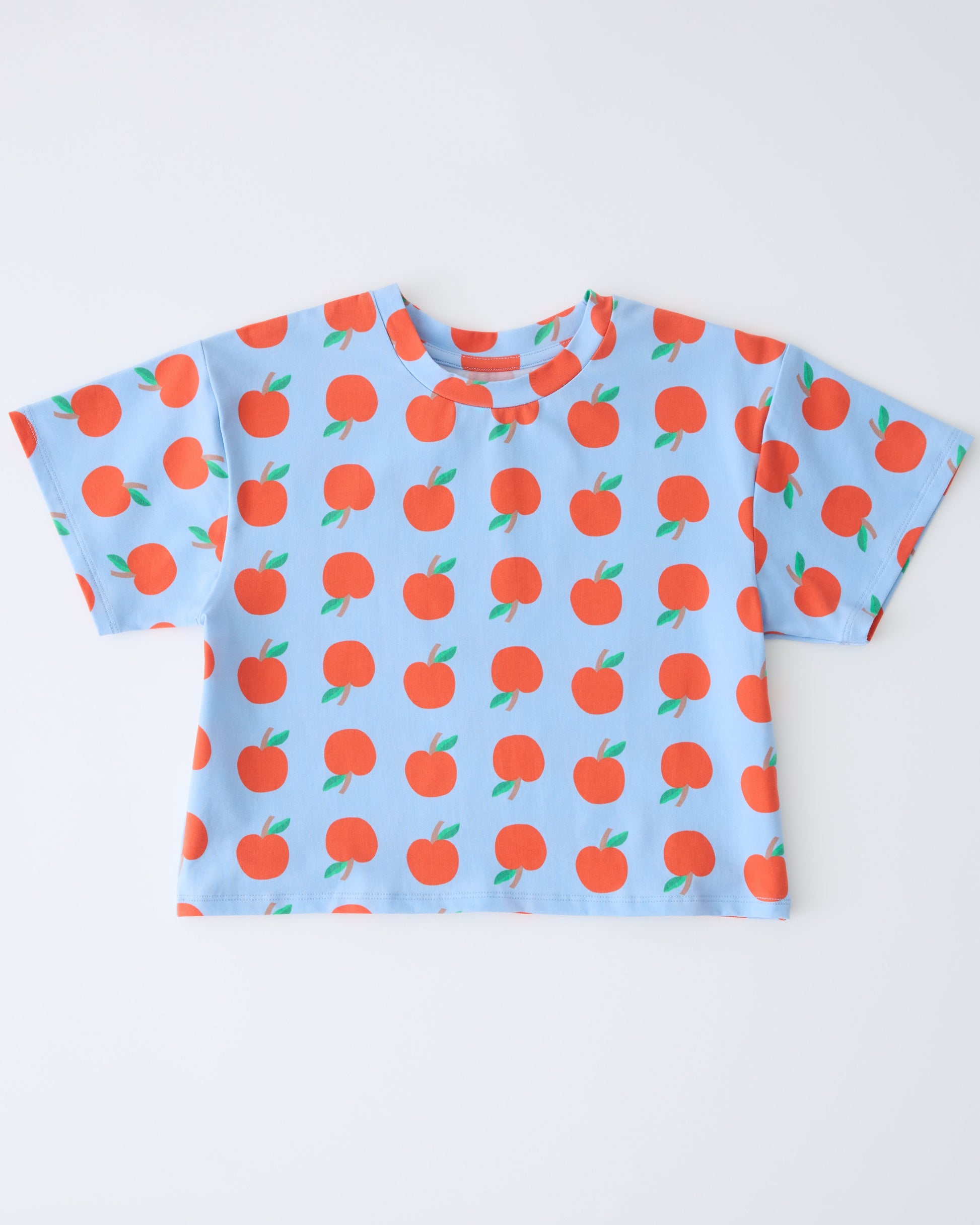Graphic Tee in Blue Apple on a gray background.