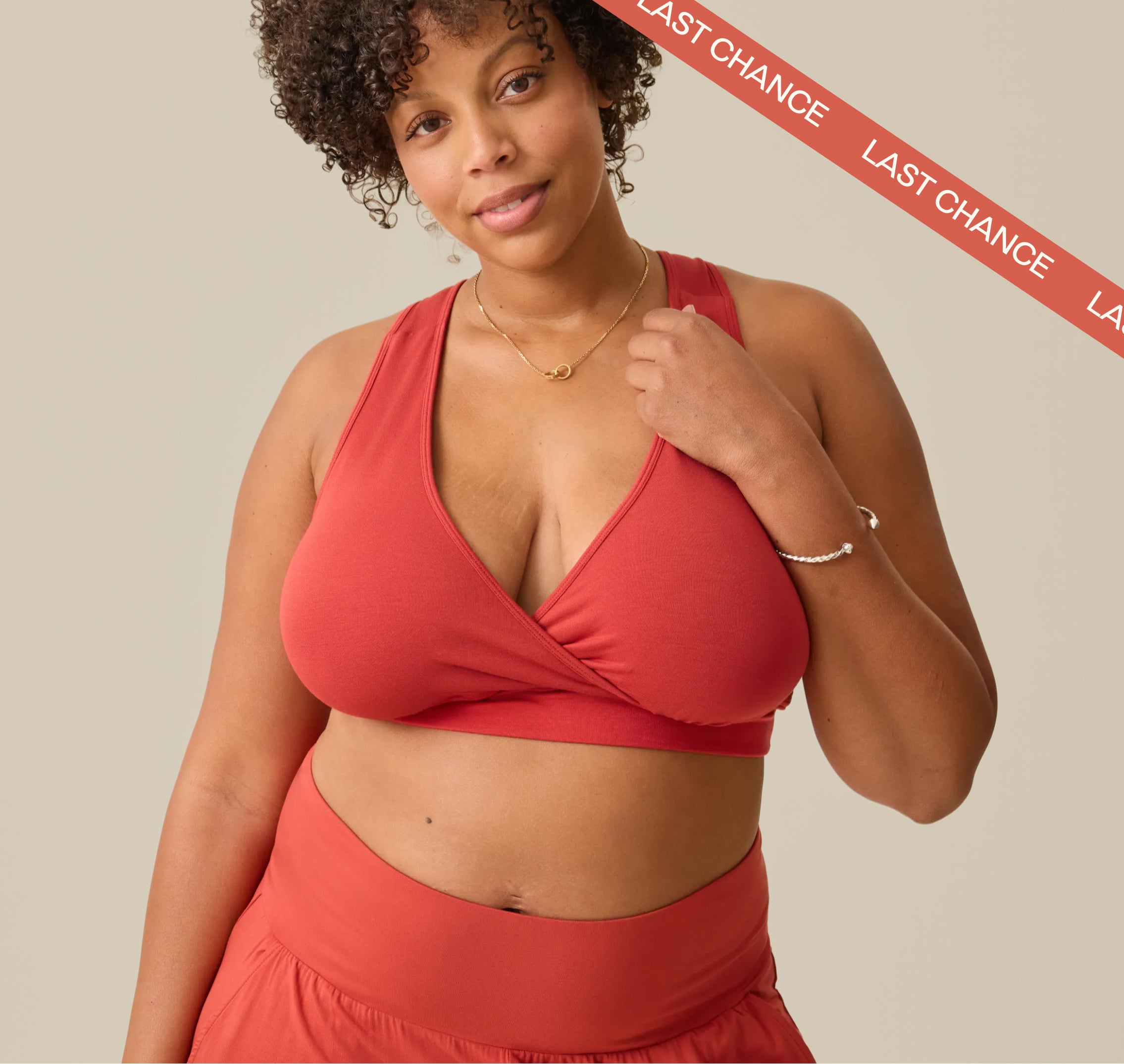 Red ribbon across right corner with white text: LAST CHANCE. Model is wearing the French Terry Racerback Nursing Bra in Spice on a beige background.
