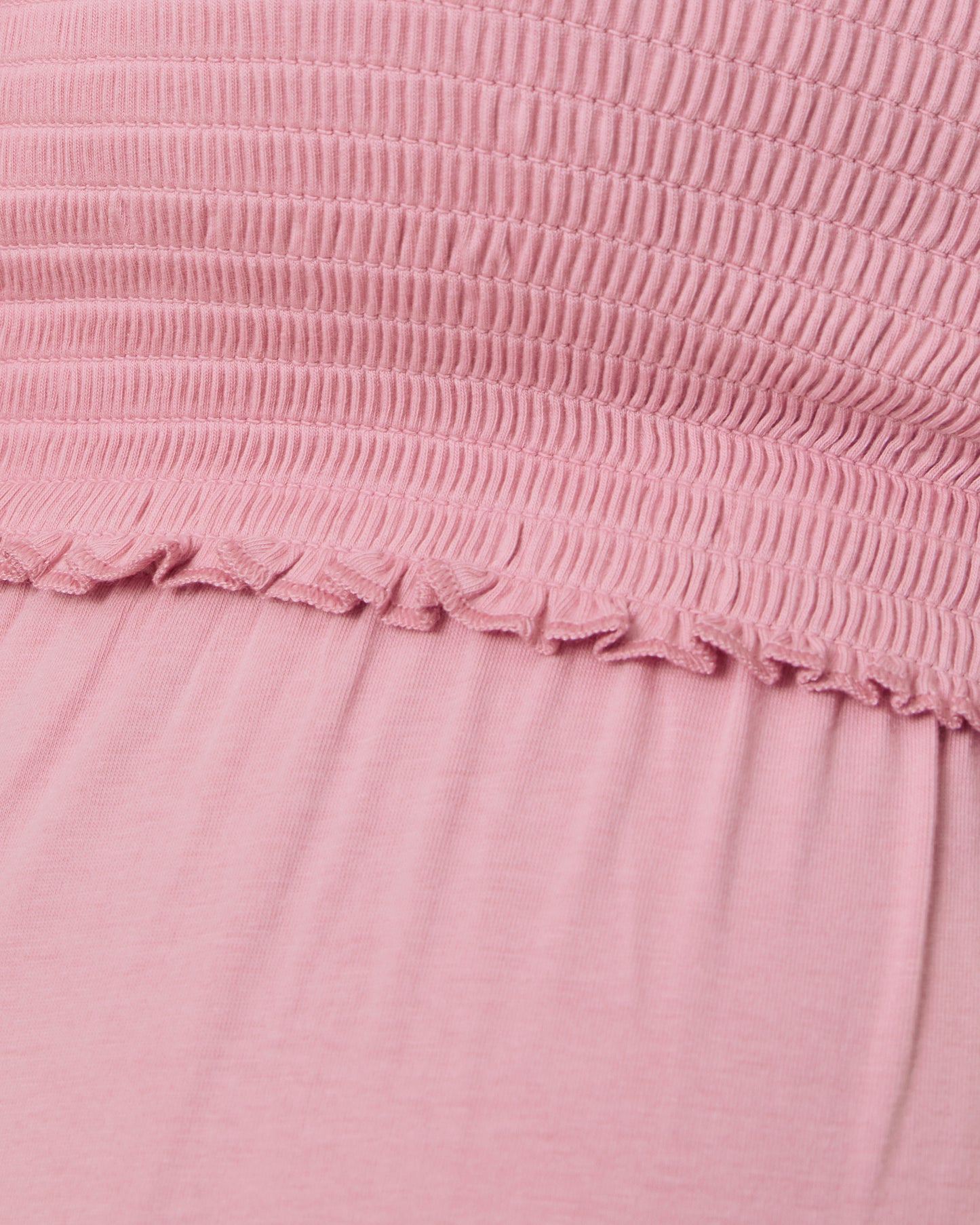 Close-up of a pink textured fabric with a frayed edge