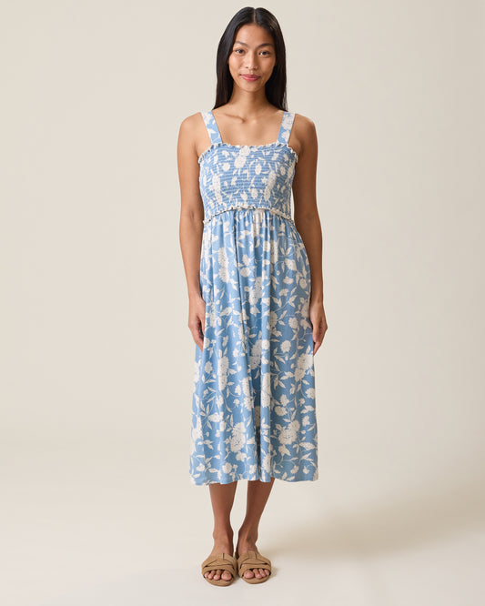 Woman wearing a blue floral dress against a beige background @model_info:Charissa is 5'7" and wearing a Small.