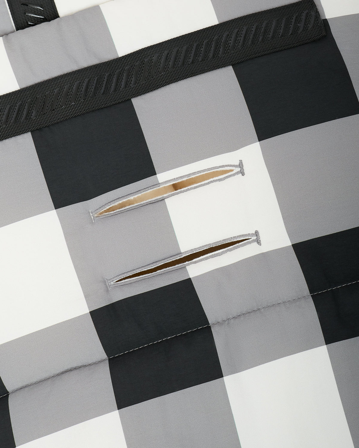 Close up of the safety buckle openings and straps on the back of the Cozy Stroller Footmuff in Buffalo Plaid.