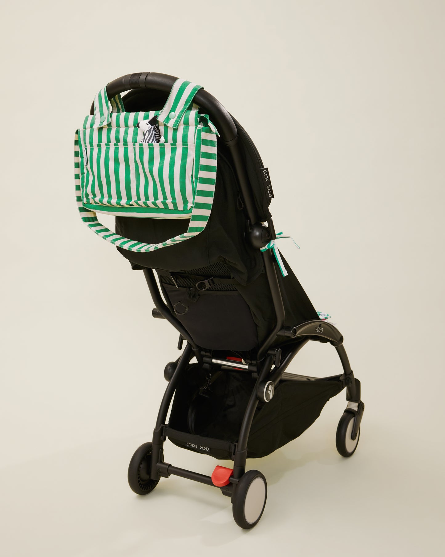 Stroller Party Caddy Bag in Green Stripe, placed on the stroller's handle