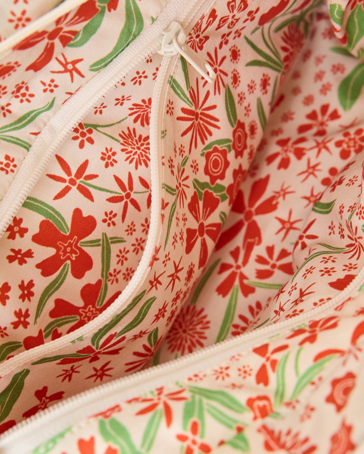 Close up of Stroller Party Caddy Bag unzipped in Superbloom on a beige background