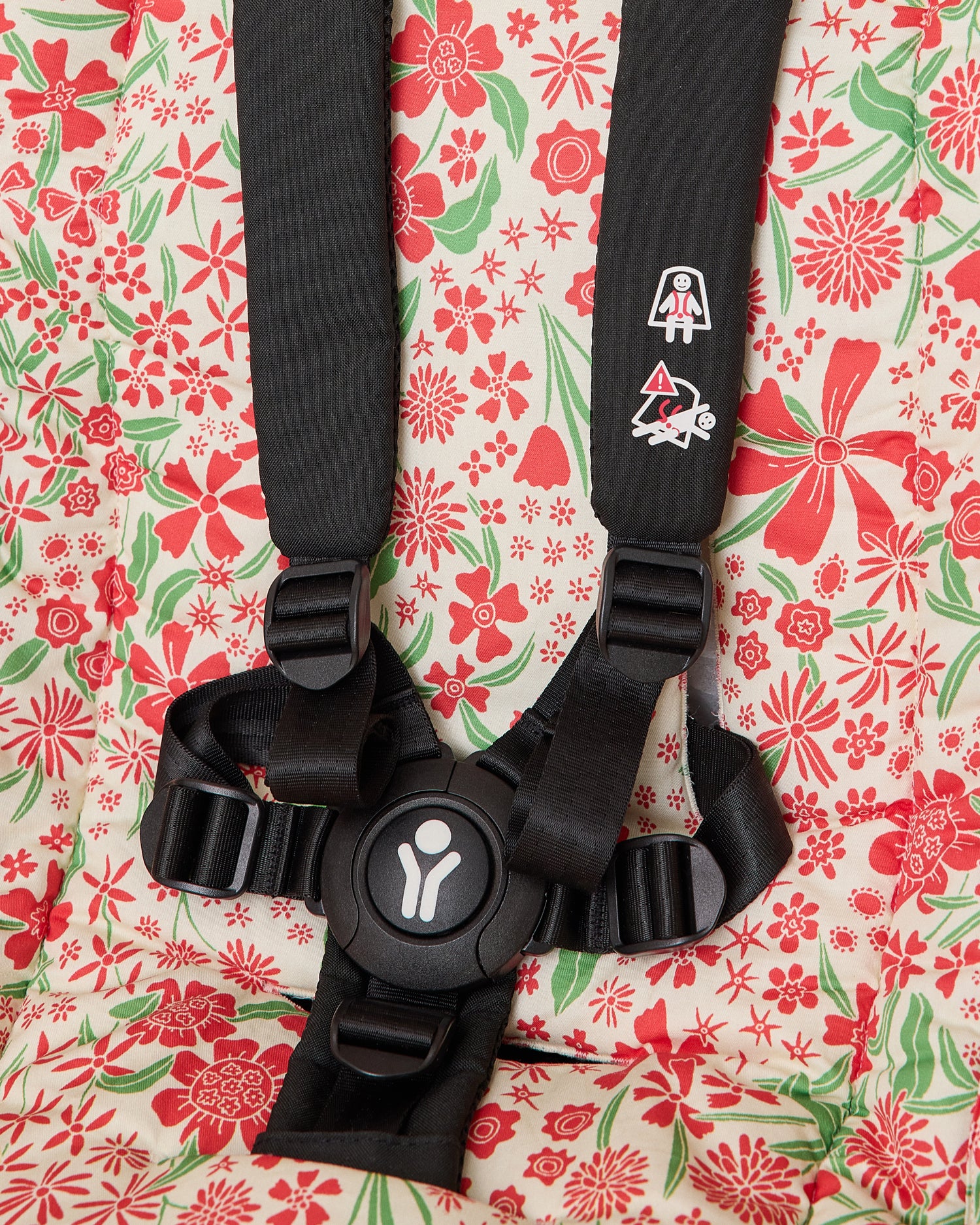 Close up of Stroller Party Seat Liner in Superbloom set in stroller seat to display how straps easily slip through to connect for baby's safety