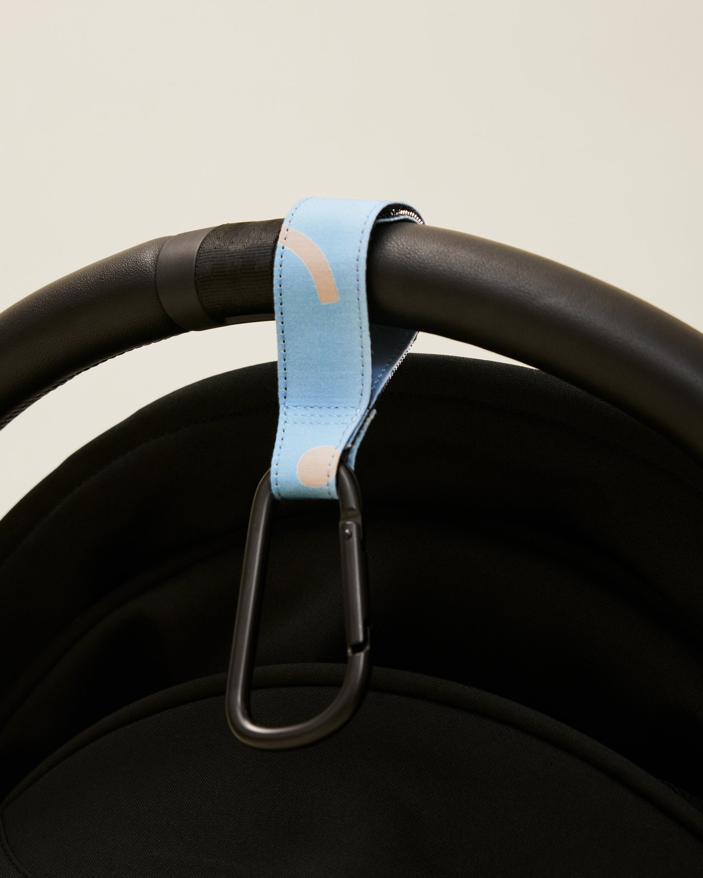 Stroller Party Clips in Sky Squiggles attached to a stroller's handle