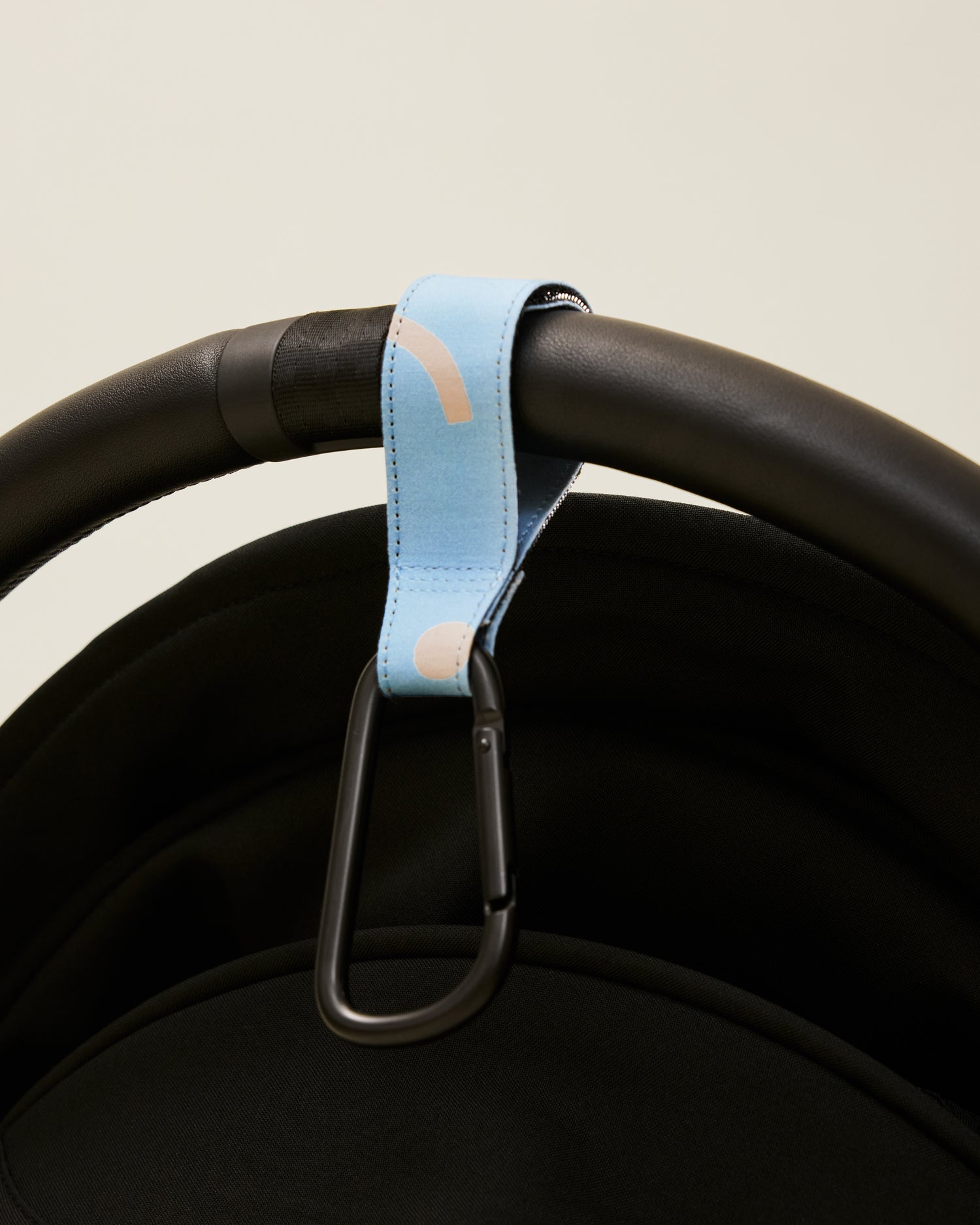 Stroller Party Clips in Sky Squiggles attached to a stroller's handle