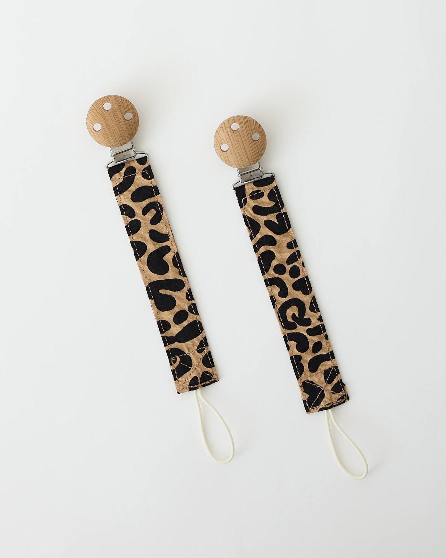 A pair of Pacifier Clip Two-Pack in Leopard on a beige background.
