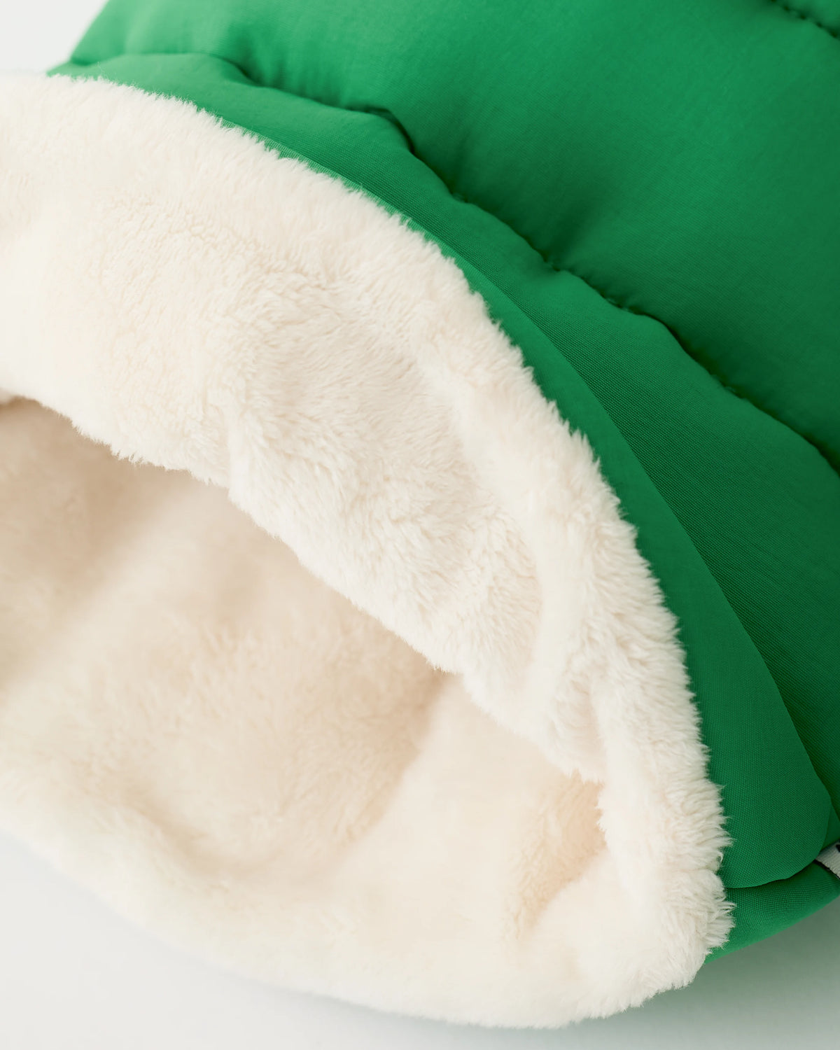 Close up of the interior fuzzy material on the Cozy Stroller Mitts in Green on an off white background.