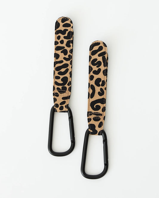 A pair of Stroller Party™ Clips (2-Pack) in Leopard on a beige background.