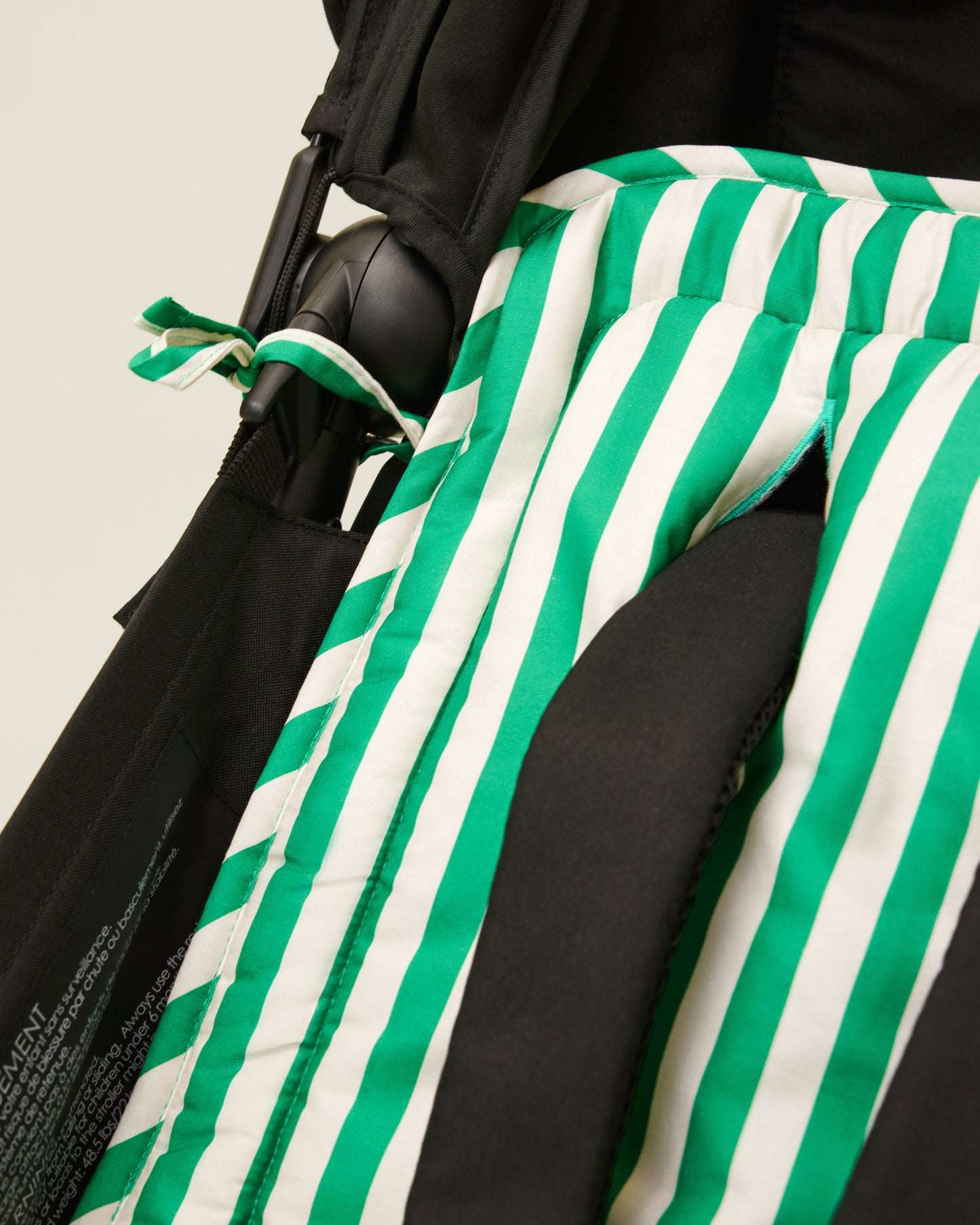 Close up of Stroller Party Seat Liner in Green Stripe on a stroller
