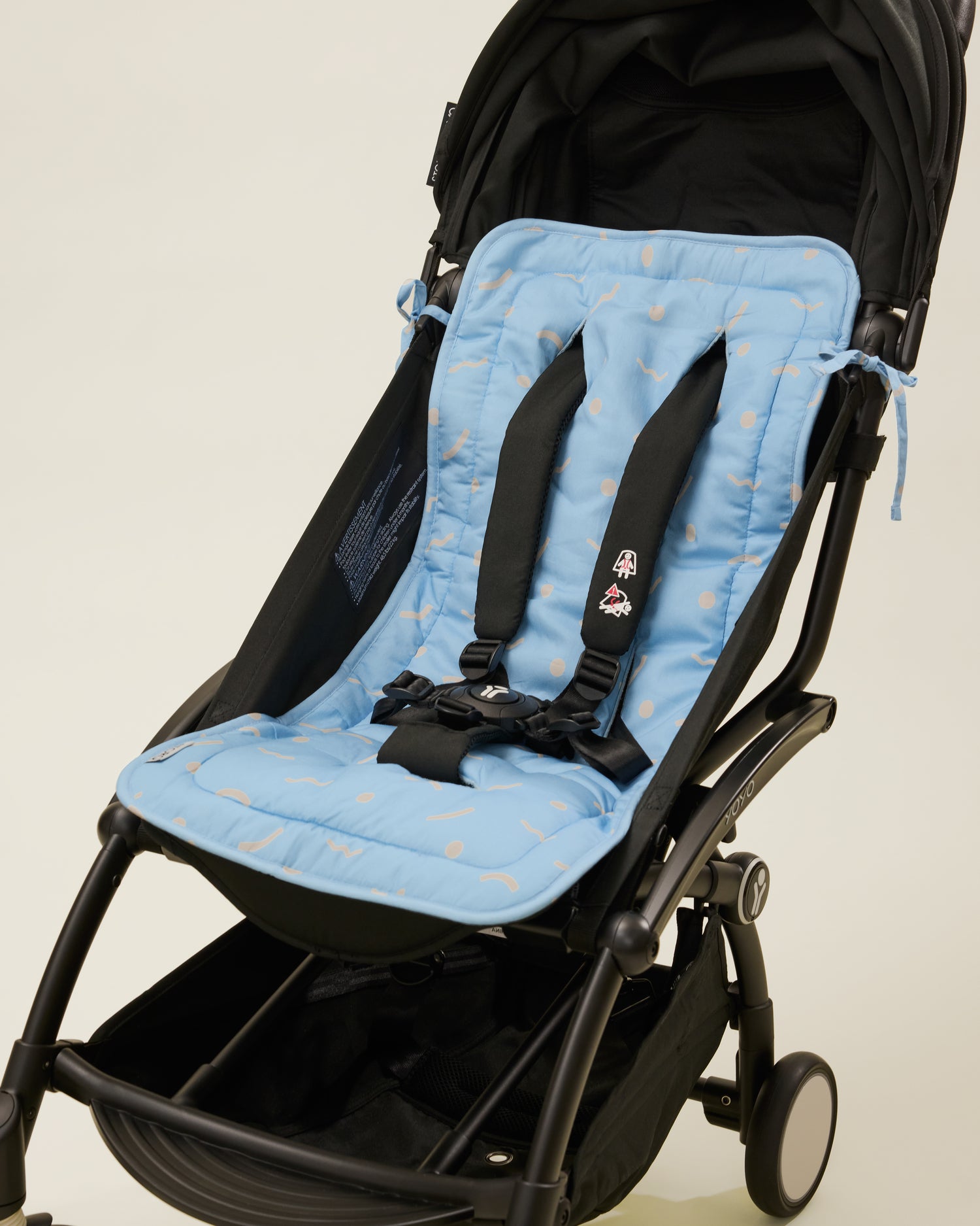 Stroller Party Seat Liner in Sky Squiggles placed on a stroller
