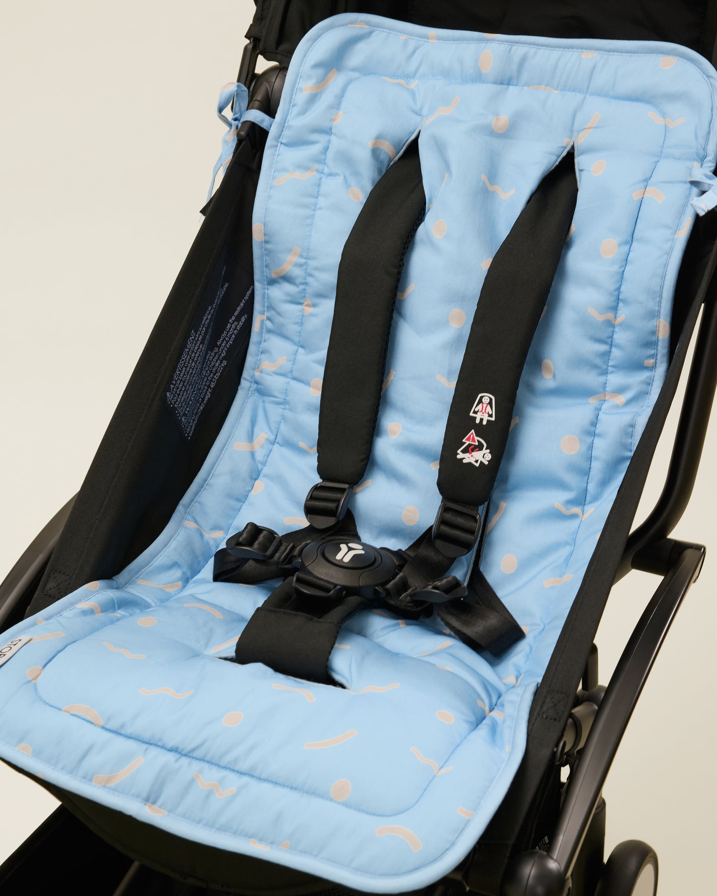 Stroller Party Seat Liner in Sky Squiggles placed on a stroller