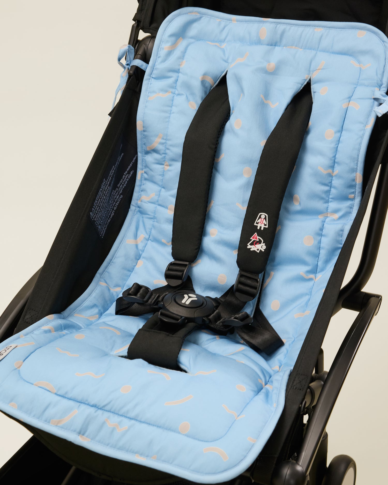 Stroller Party Seat Liner in Sky Squiggles placed on a stroller
