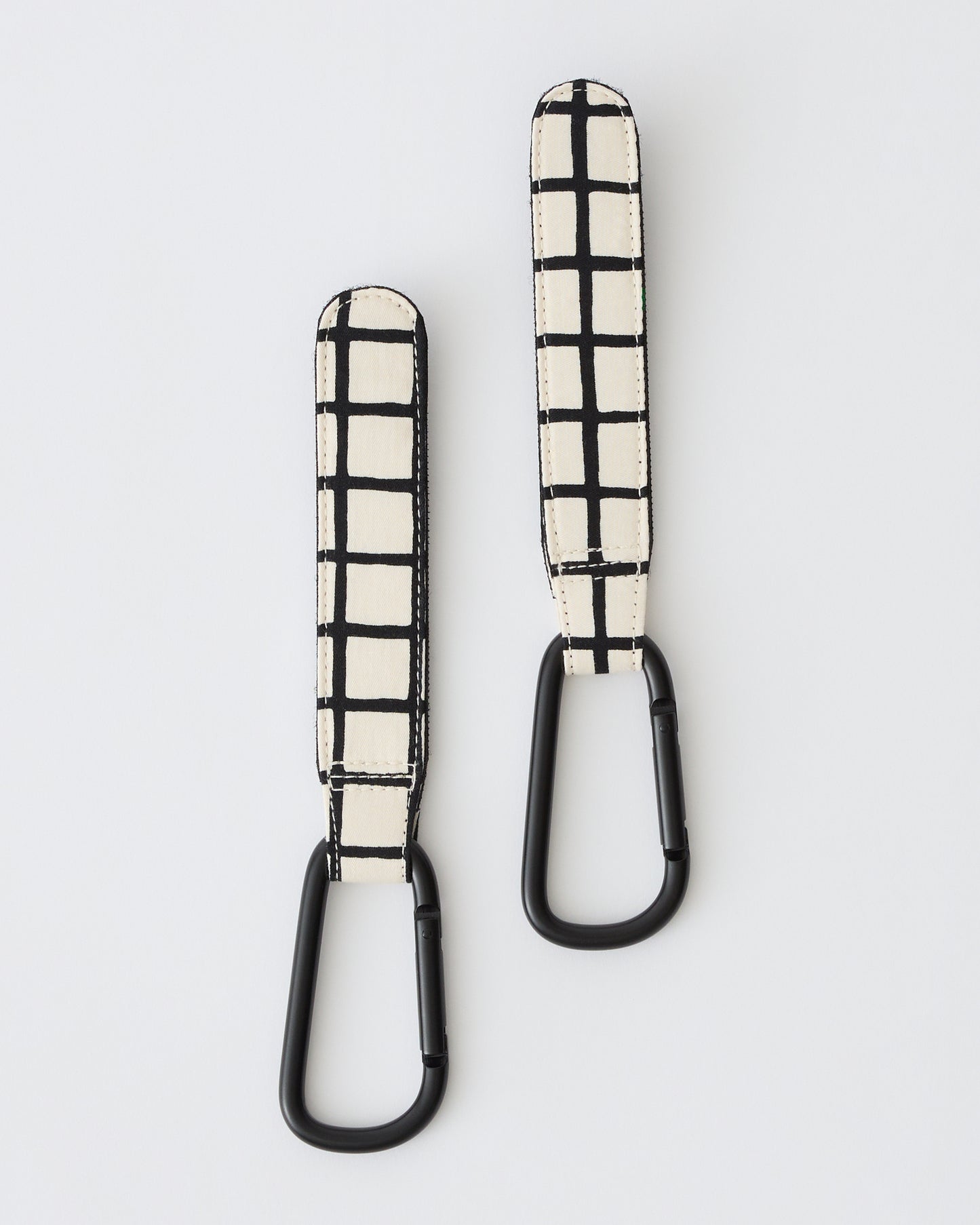 Stroller Party™ Clips (2-Pack) in Black Grid on a beige background.