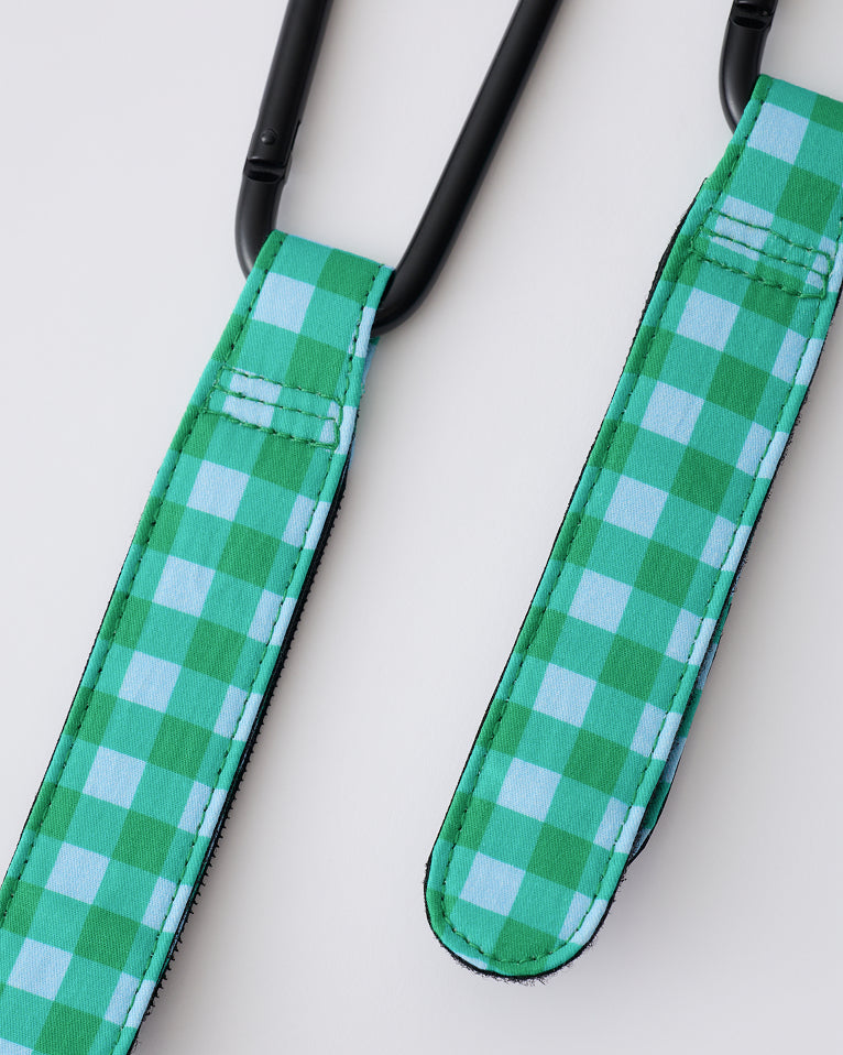 Stroller Party™ Clips (2-Pack) in Teal Gingham on a beige background.