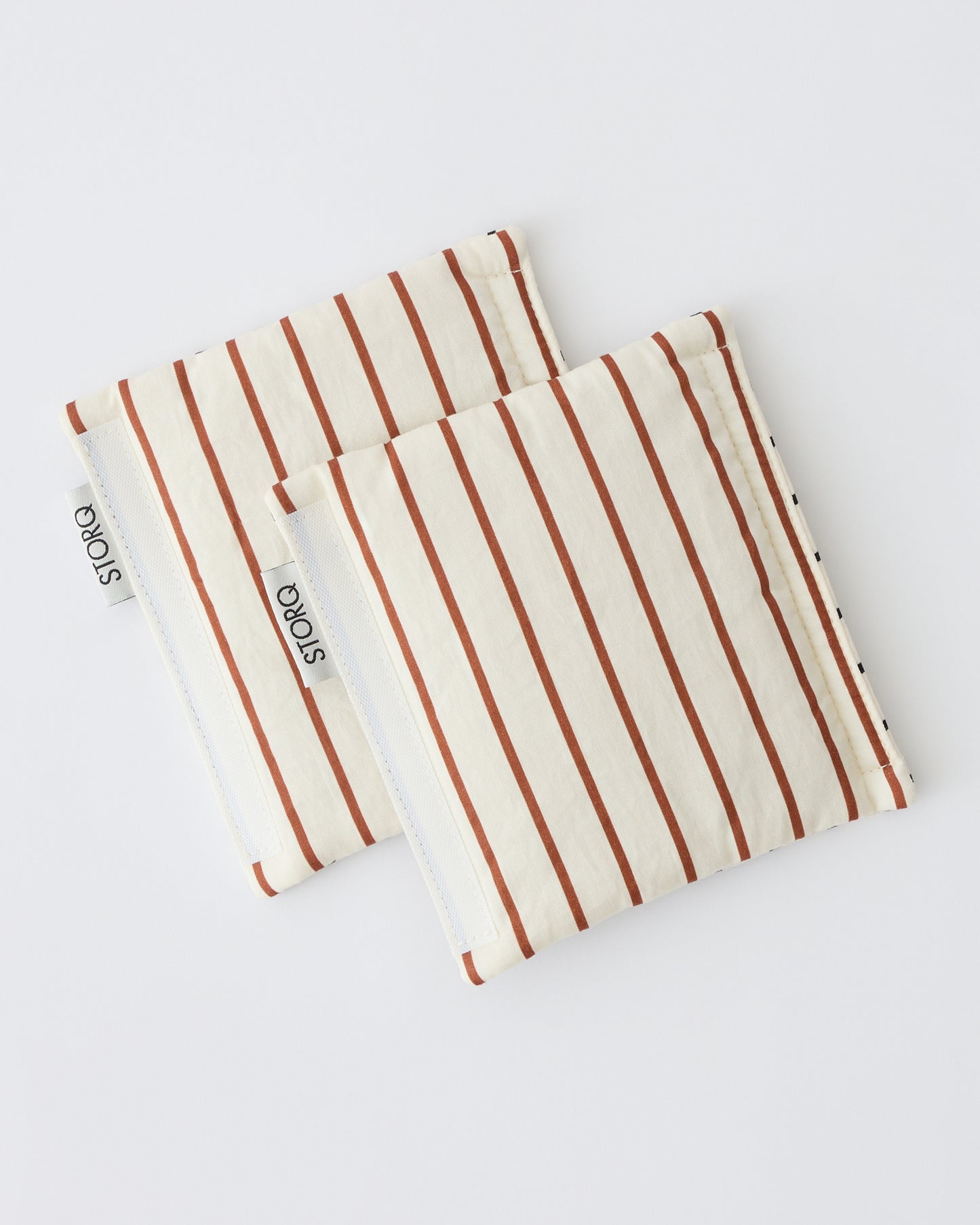 Unfolded Stroller Party™ Strap Covers in Black Grid on a beige background. Straps showing reversed side for new pattern.