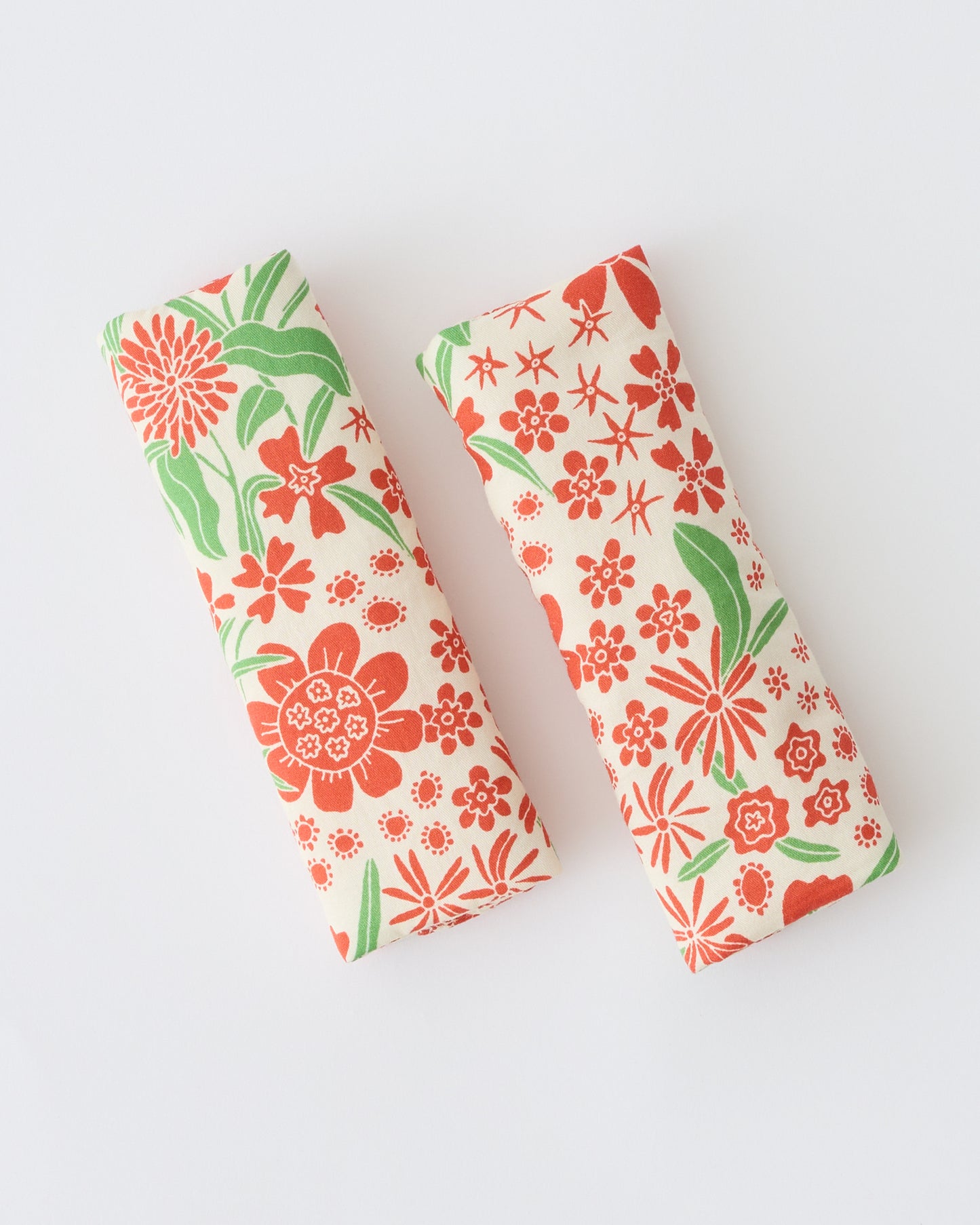 Folded Stroller Party™ Strap Covers in Superbloom on a beige background.