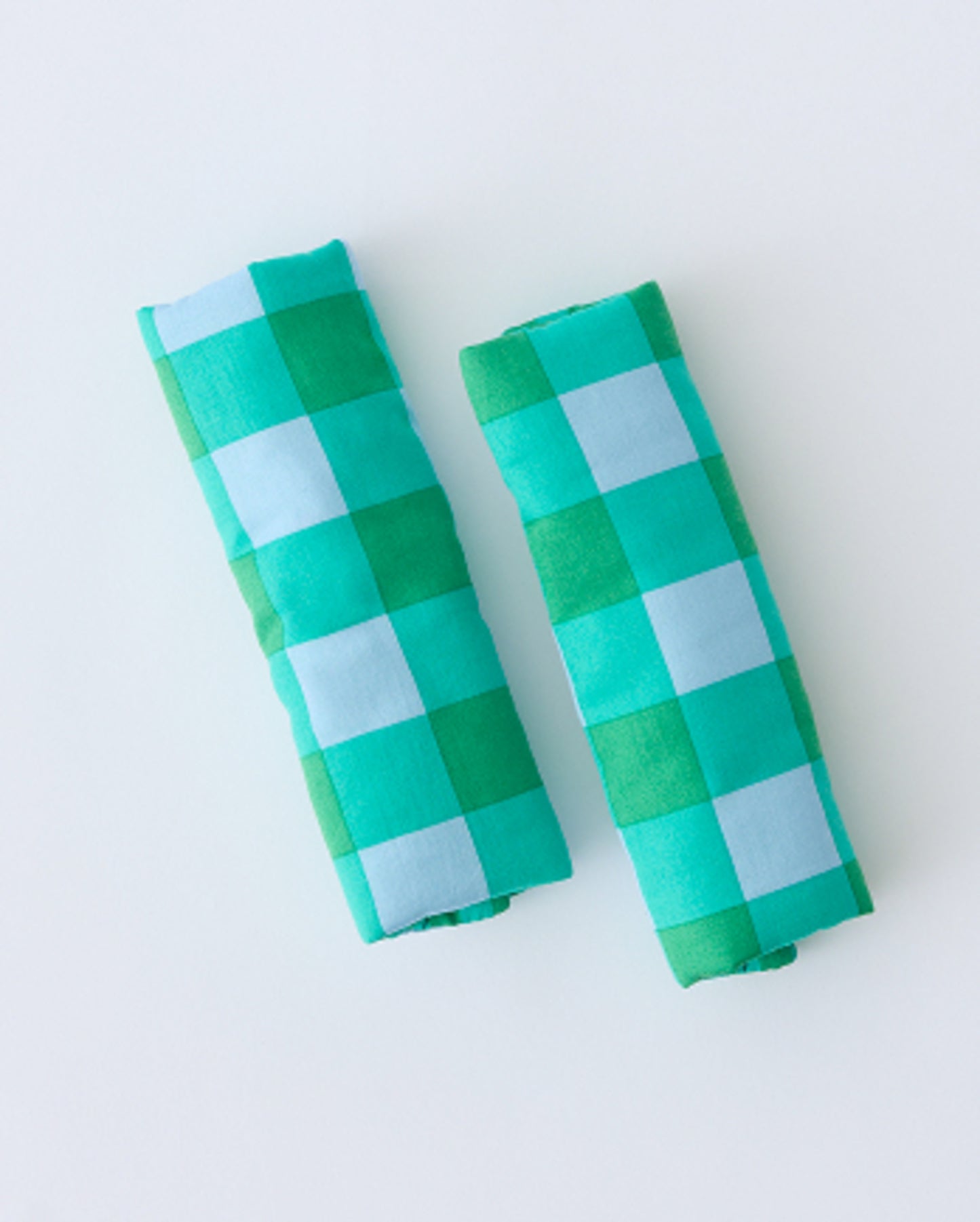 Folded Stroller Party™ Strap Covers in Teal Gingham on a beige background.