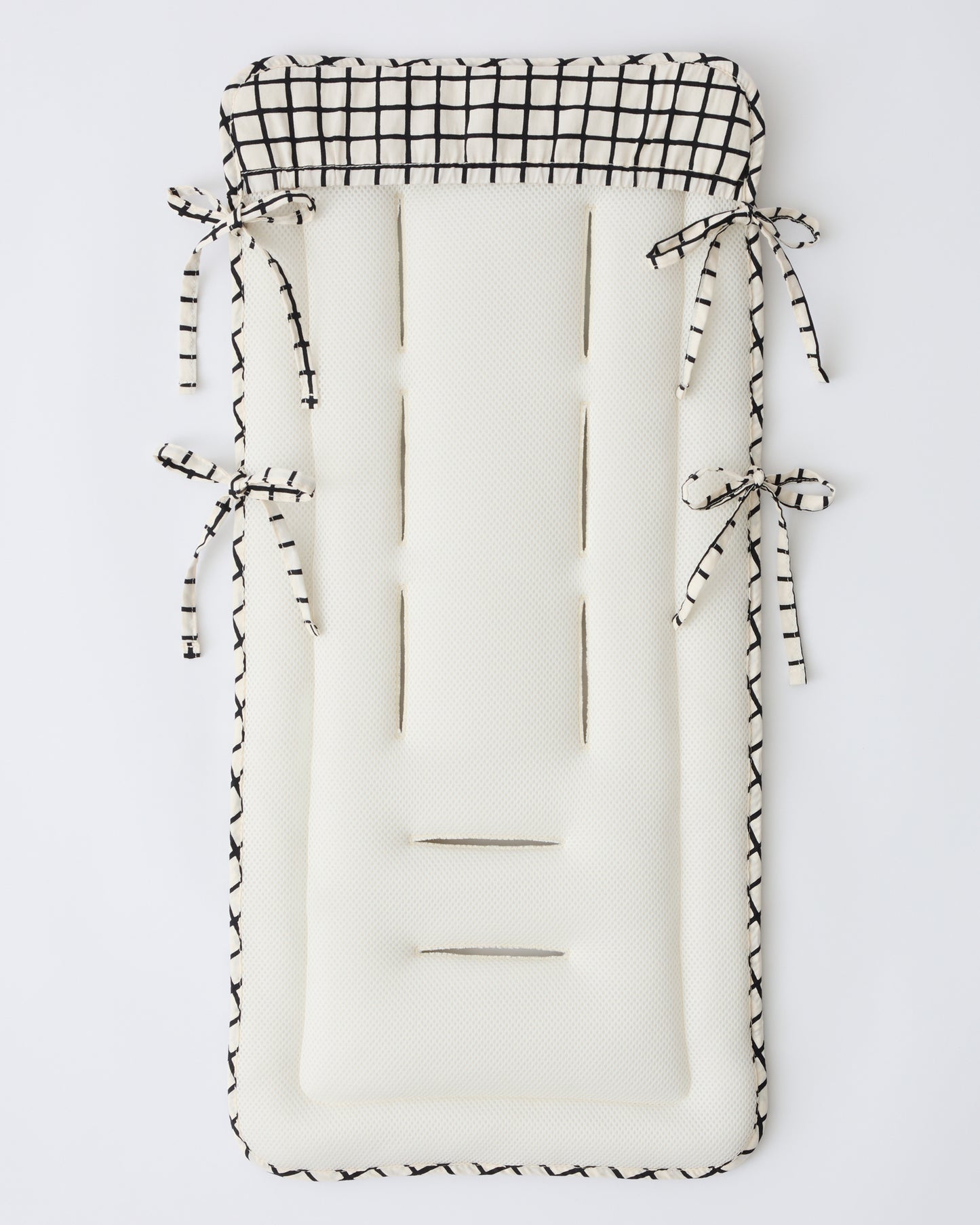 Back view to show cover and cushion of the Stroller Party™ Seat Liner in Black Grid on a beige background. 