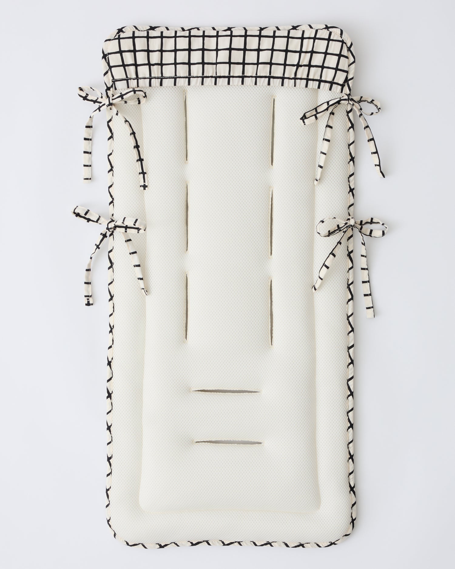 Back view to show cover and cushion of the Stroller Party™ Seat Liner in Black Grid on a beige background. 