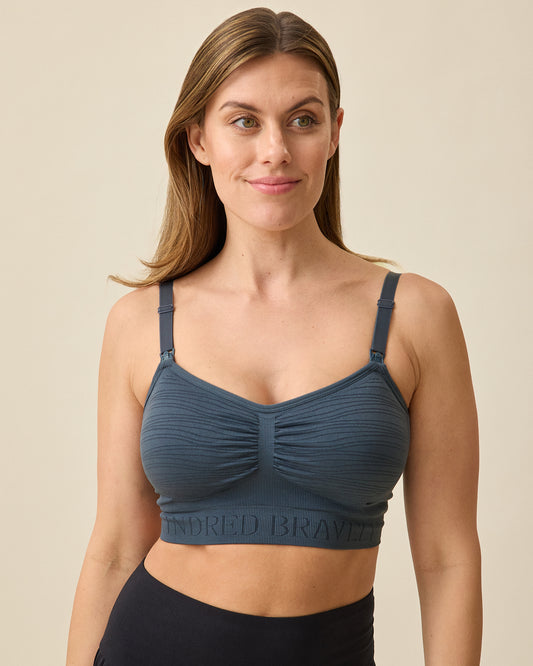 Model is wearing Sublime® Hands-Free Pumping & Nursing Bra in Midnight Blue on a beige background @model_info:Brittany is wearing a Small.