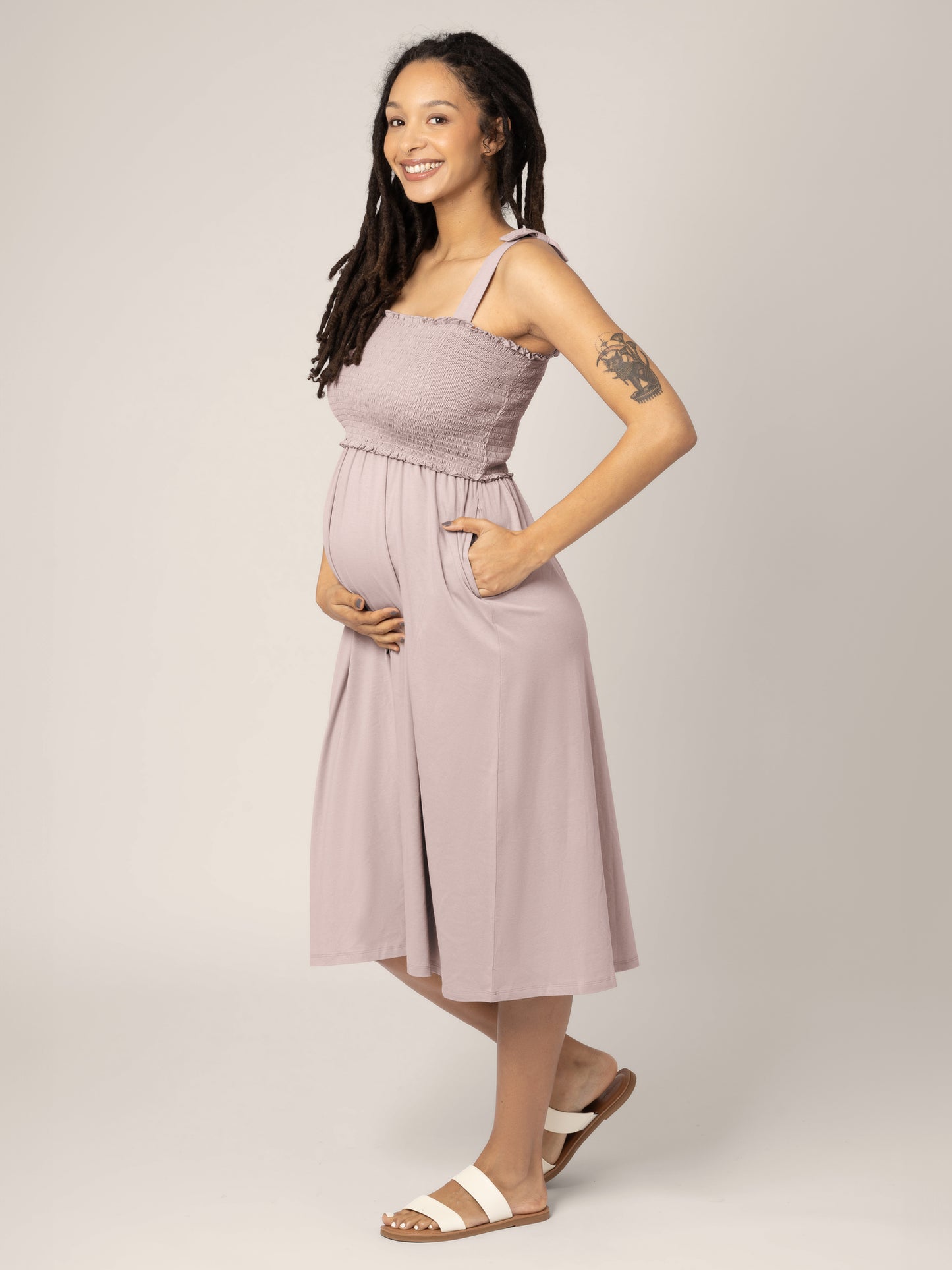 Pregnant model wearing the Sienna Smocked Maternity & Nursing Dress in lilac stone