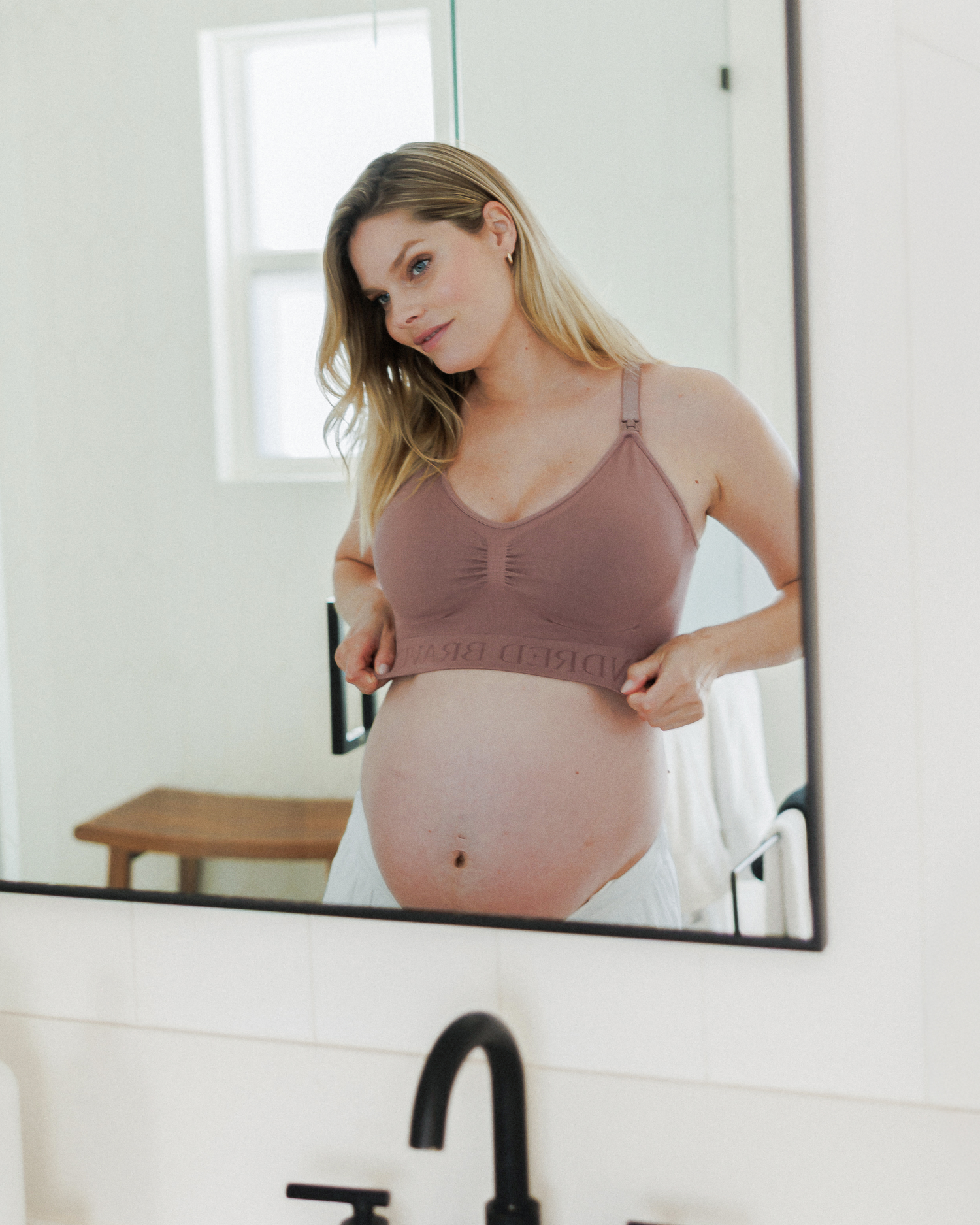 Model looking in the mirror while wearing the Simply Sublime® Nursing Bra in Twilight 