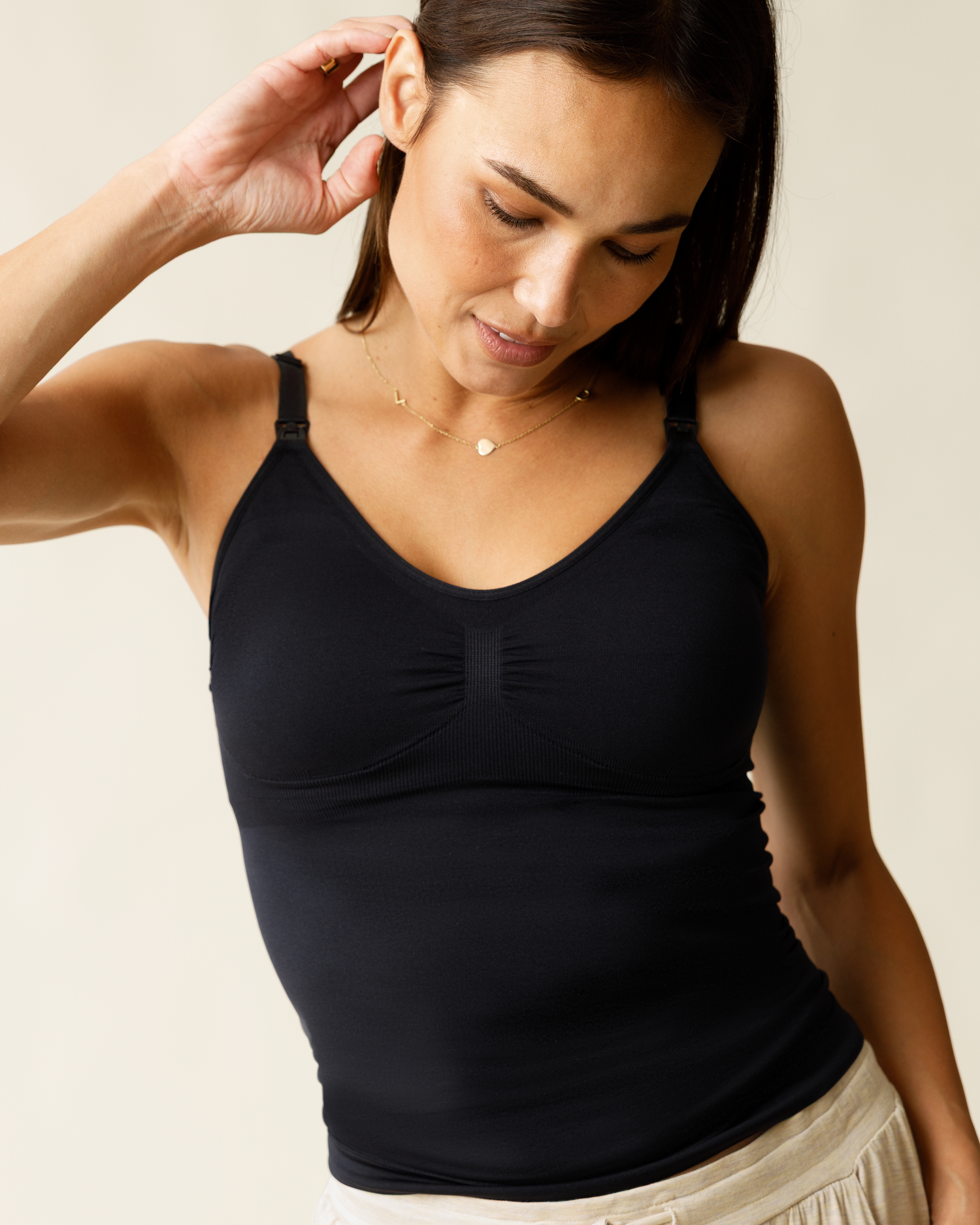 Woman wearing the Simply Sublime® Maternity & Nursing Tank in Black against a beige background @model_info:Lisa is wearing a Small.