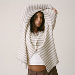 Model is wearing Ultra Soft Maternity & Postpartum Cardigan in Tan & White Stripe, Maternity & Postpartum Wide Leg Trouser in Brown and a nursing white tee, on a beige background.