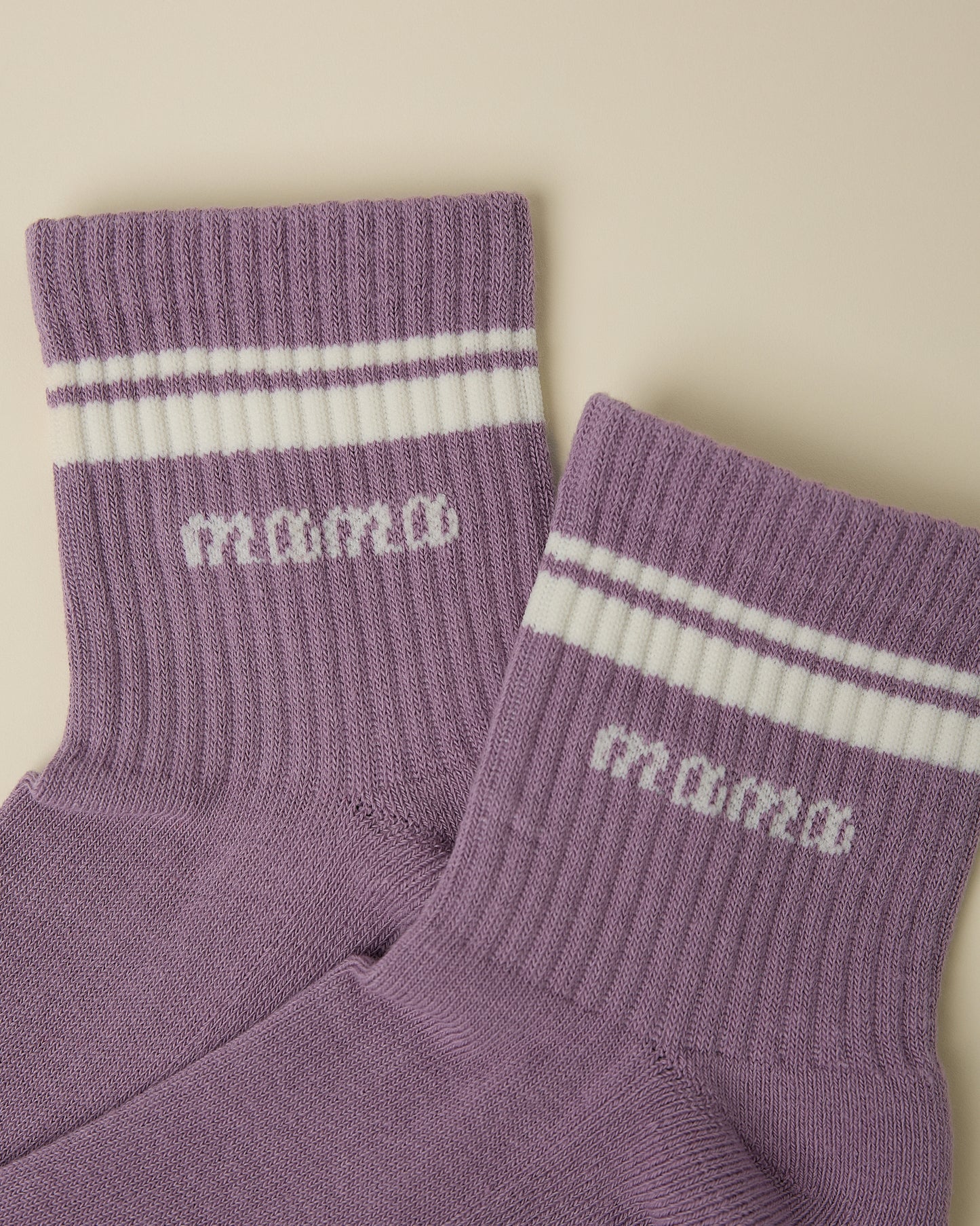 Close up of a pair of Non-Slip Quarter Crew Socks in Dusty Mauve & Ivory on a beige background.