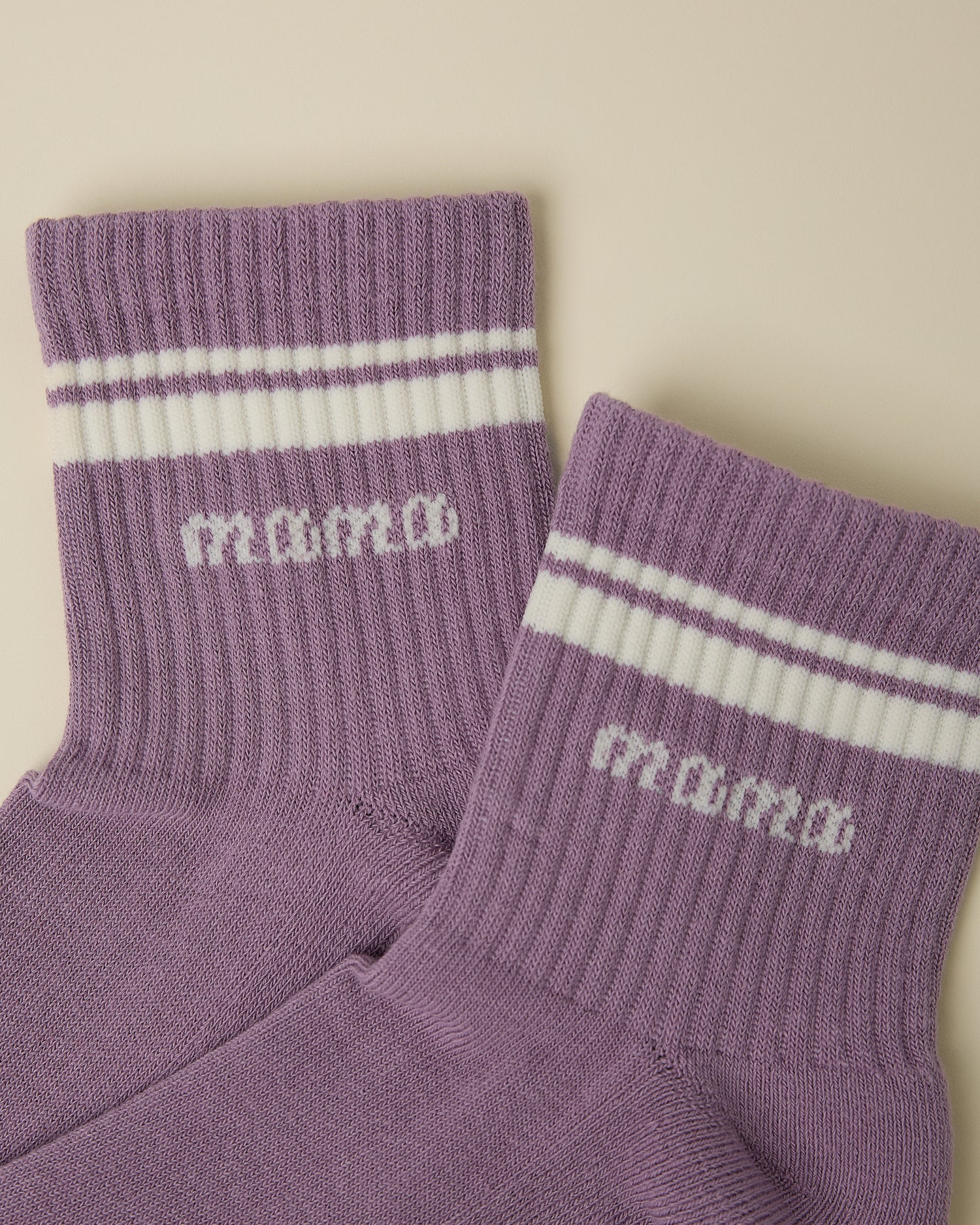 Close up of a pair of Non-Slip Quarter Crew Socks in Dusty Mauve & Ivory on a beige background.