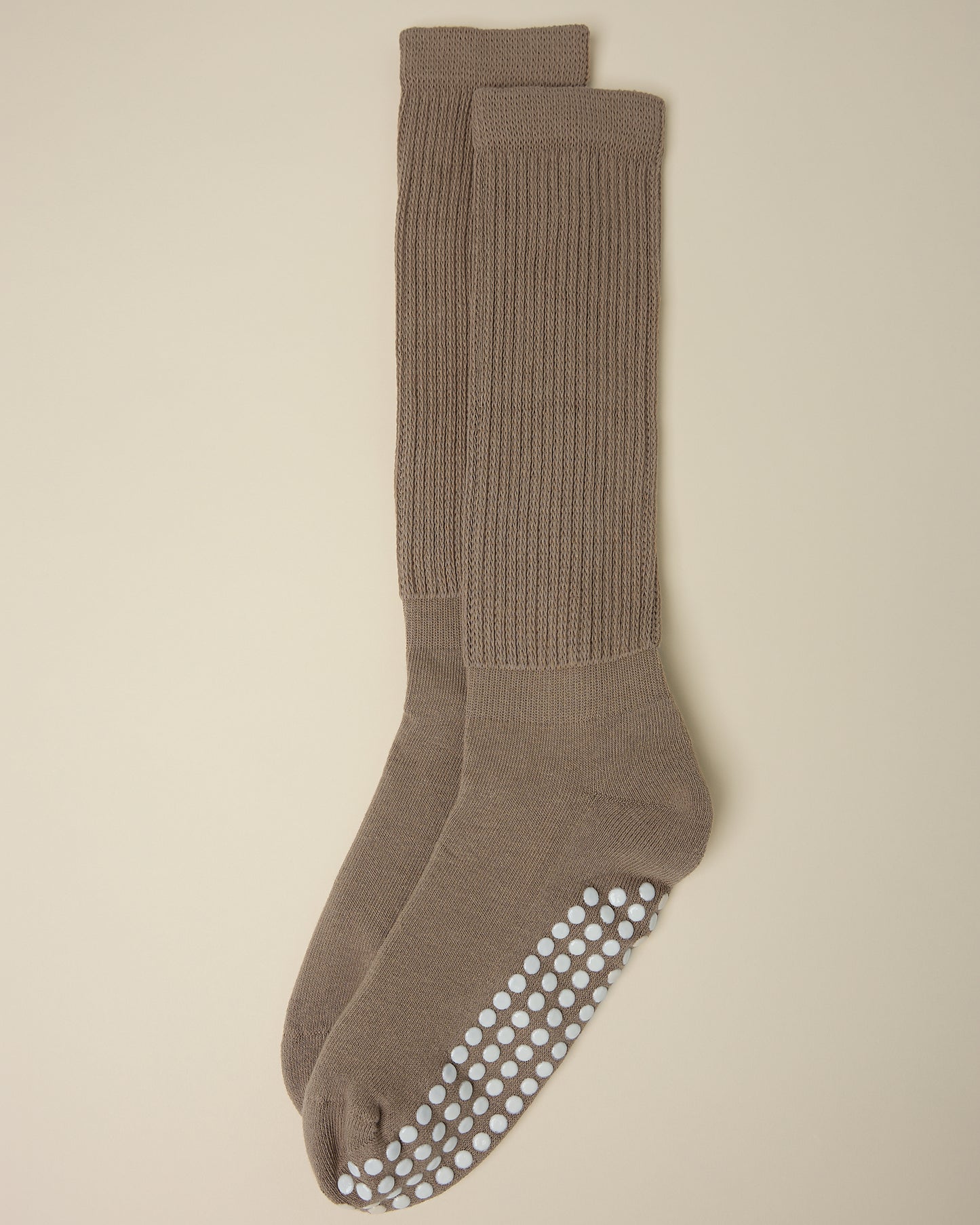 A pair of Non-Slip Slouchy Socks in Taupe on a beige background