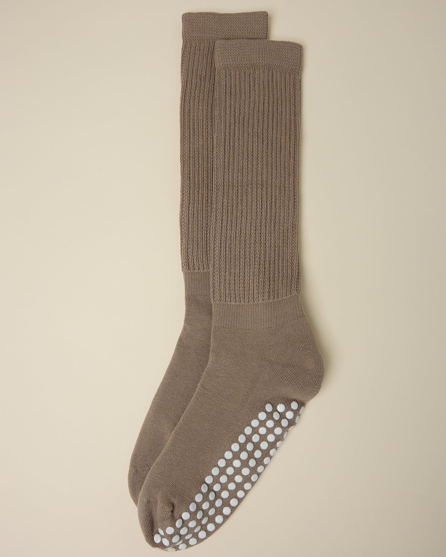 A pair of Non-Slip Slouchy Socks in Taupe on a beige background